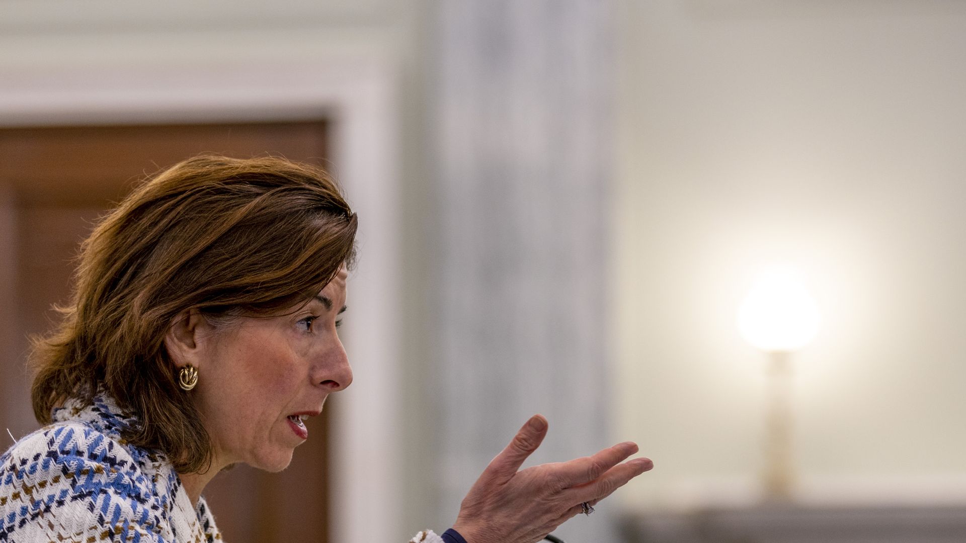 Gina Raimondo uses her hands to make a point in a suit