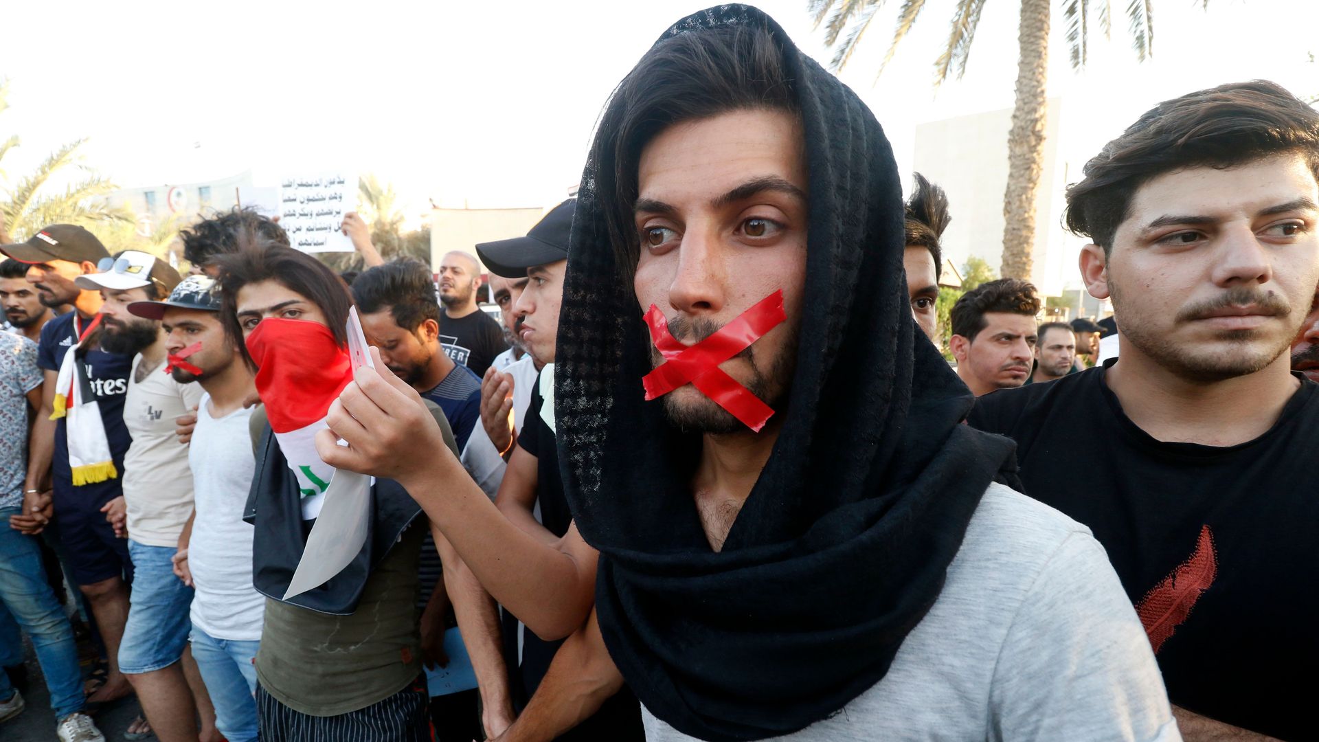 Iraqis with tape on their mouths attend a protest in the southern city of Basra on August 24, 2018.