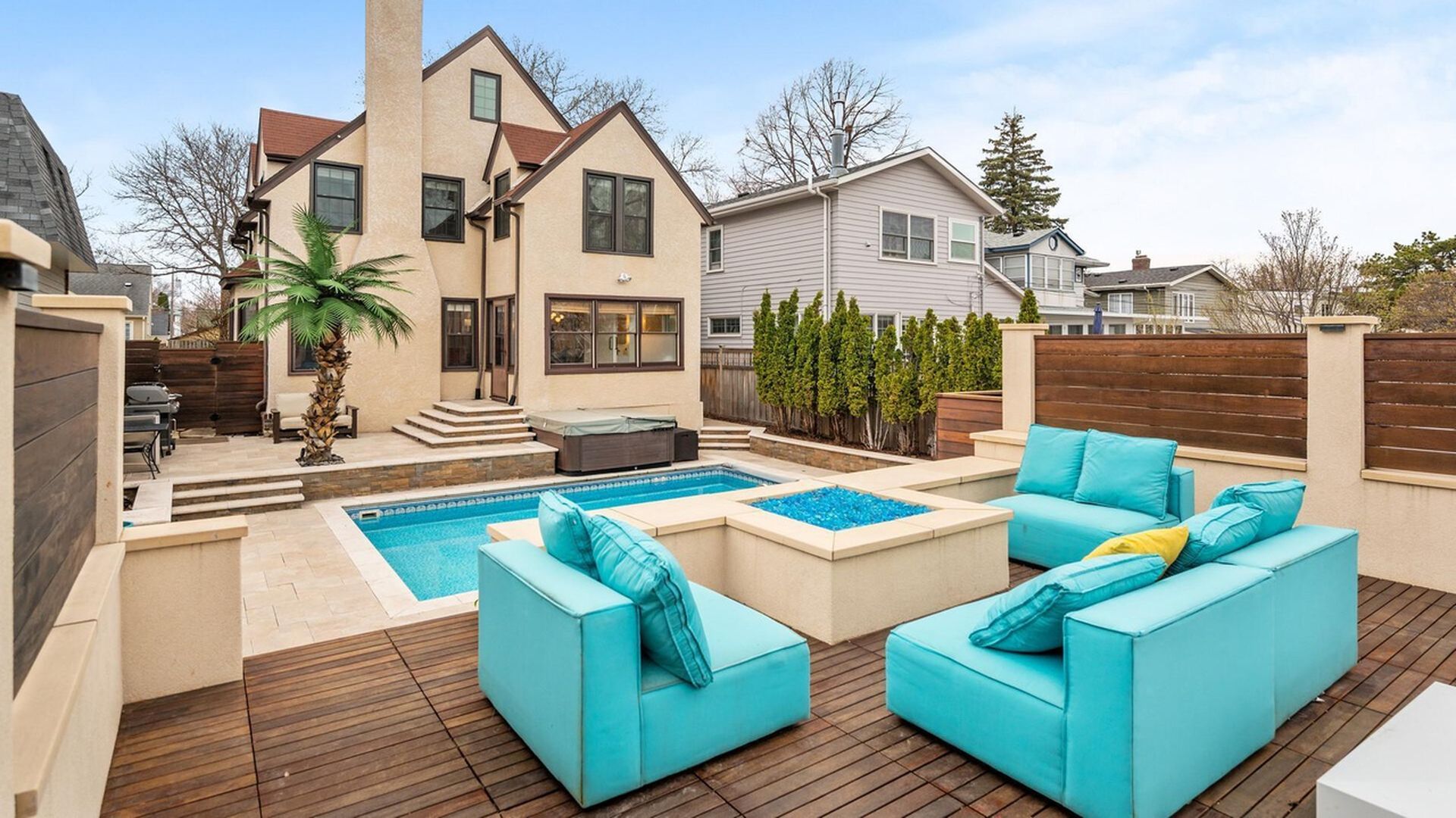 backyard of home with pool and fire pit surrounded by blue loungers