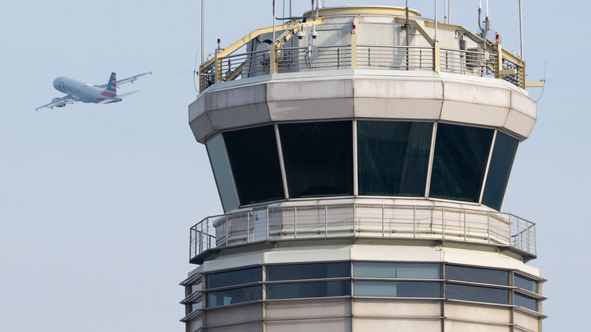 An American Airlines Airbus A319 airplane takes off past the air traffic control tower at Ronald Reagan Washington National Airport.