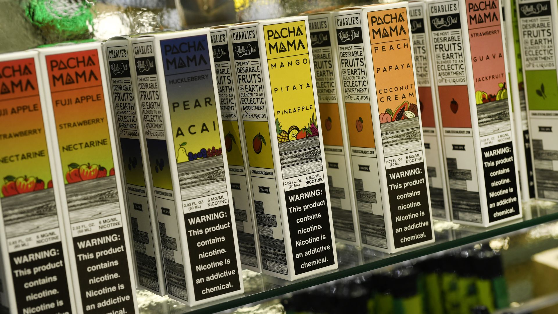 Several small, colorful rectangular boxes on a glass shelf. 