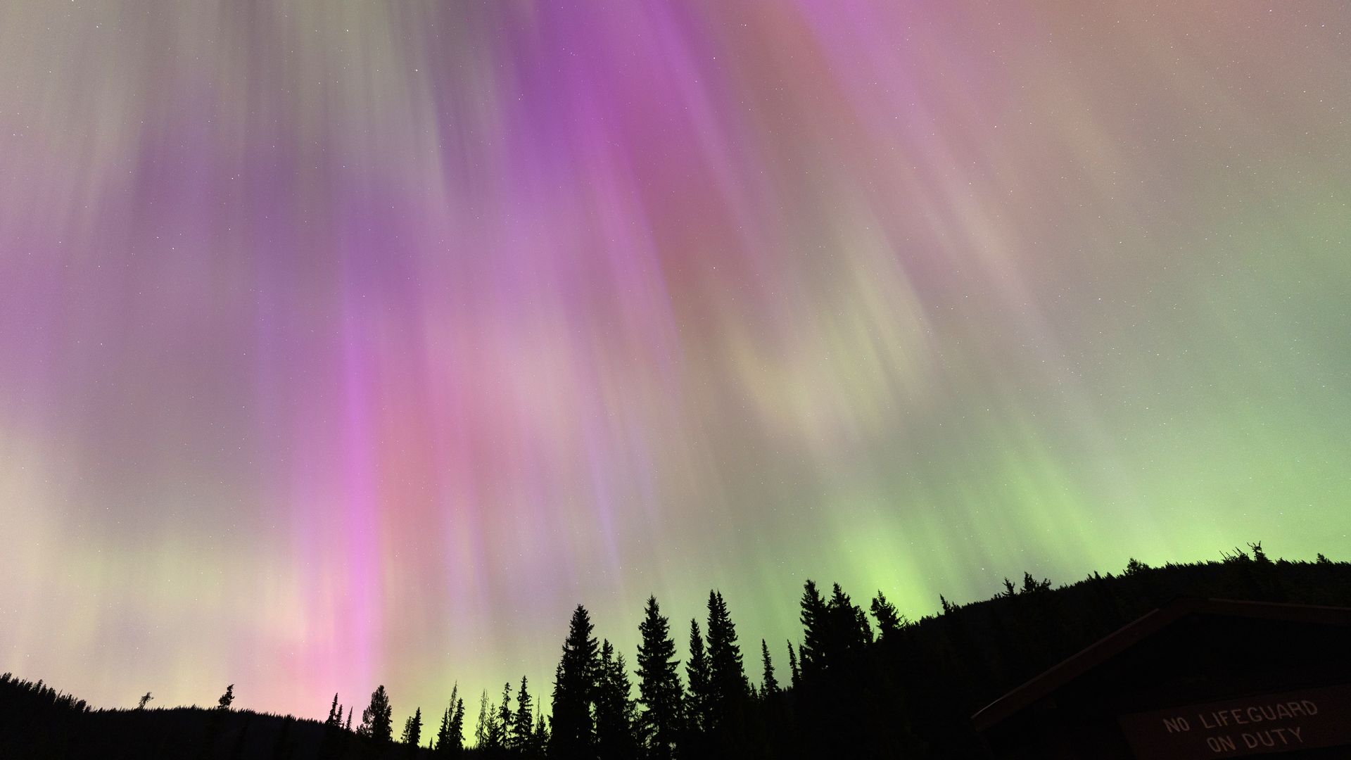 Different shades of pinks and greens light up the sky because of the Aurora borealis or Northern Lights.