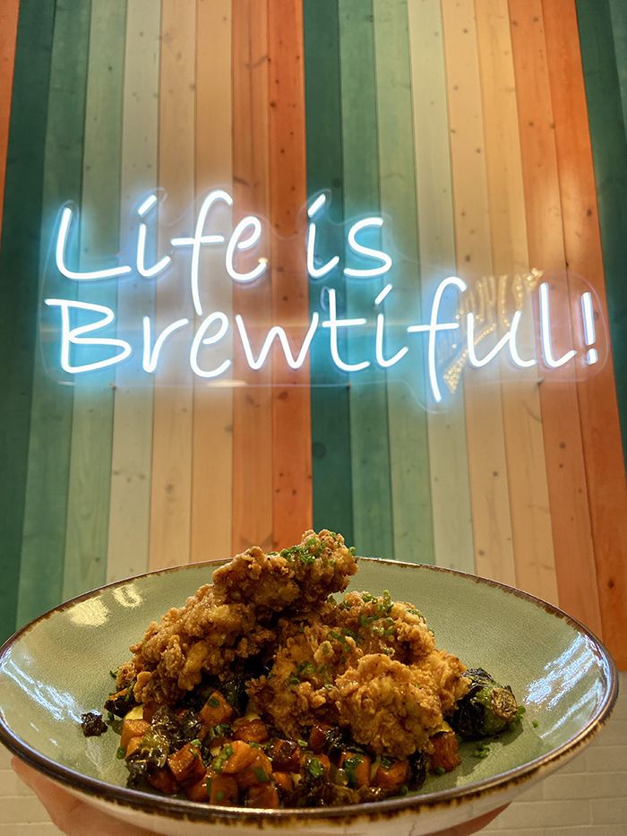 Sycamore Brewing chicken and grits in front of a 