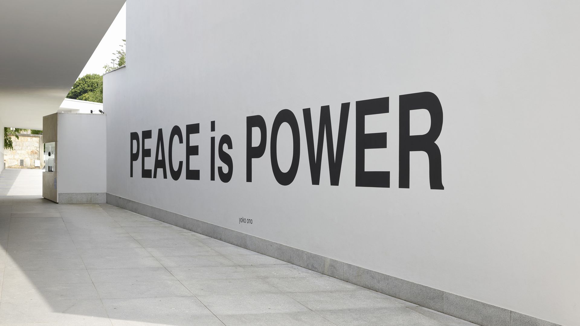 A white wall with black text: PEACE is POWER