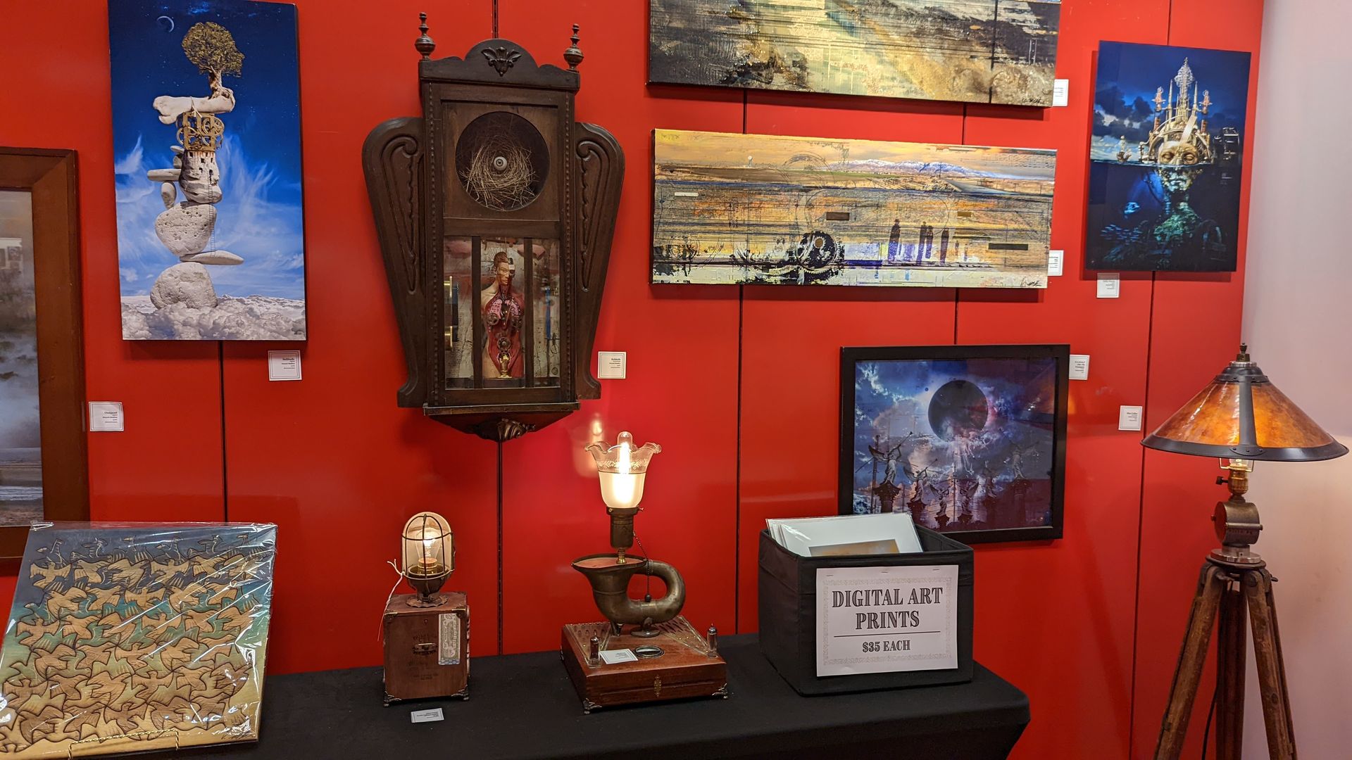 Artwork hangs on a red gallery wall.