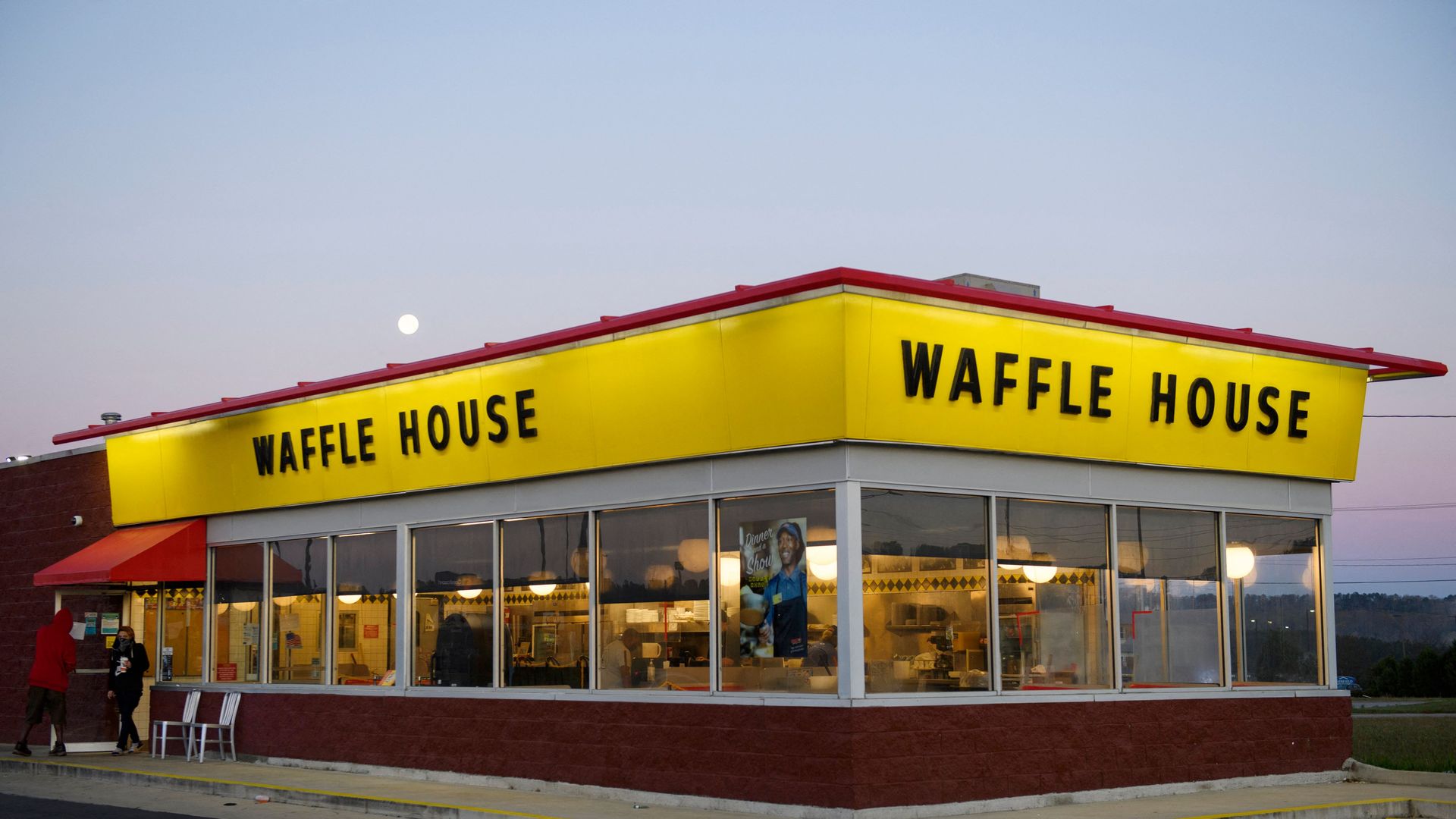 Customers exit a Waffle House restaurant in the early morning as the sun starts to rise