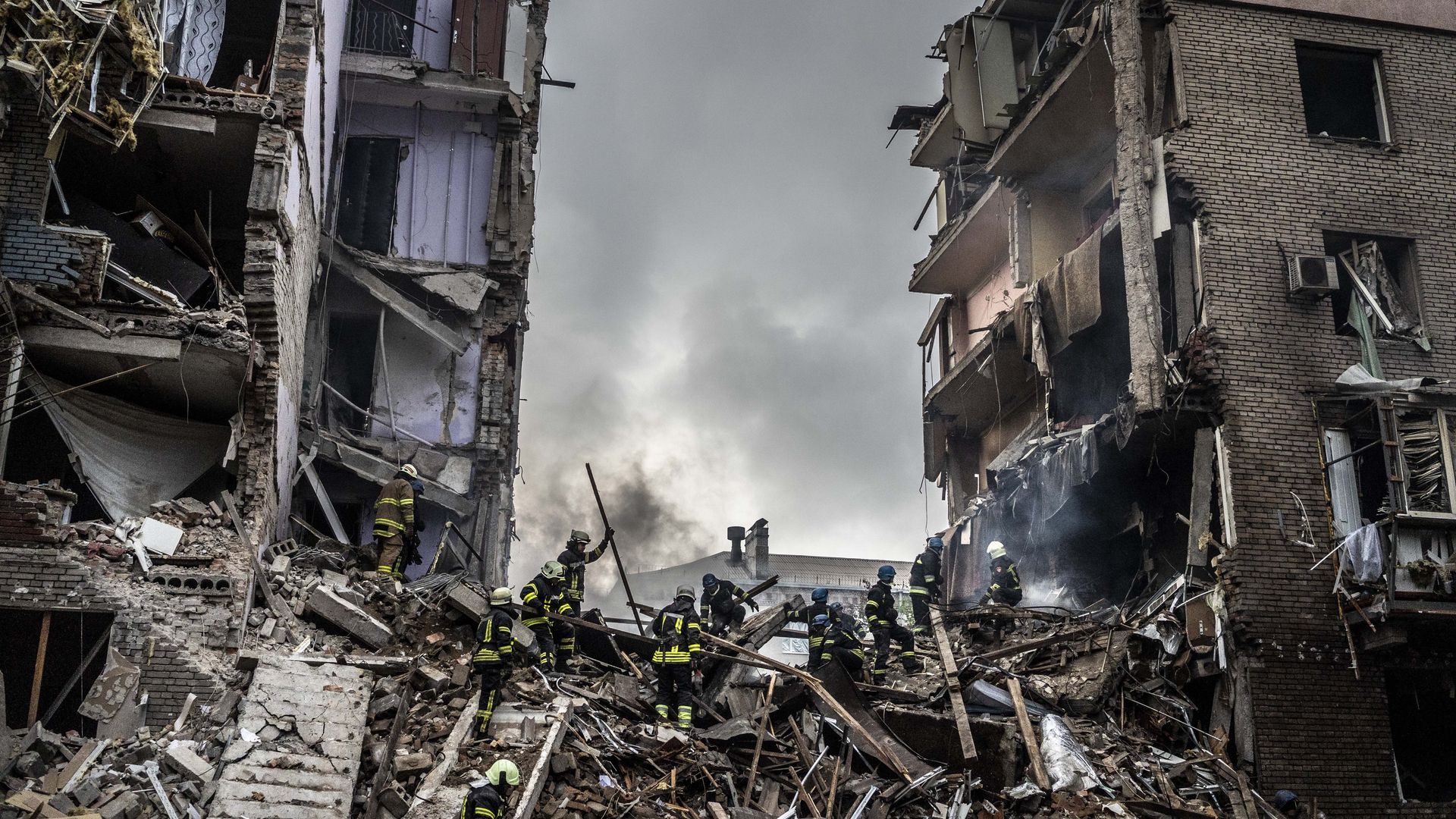 Firefighters conduct work in a damaged building after missile strike