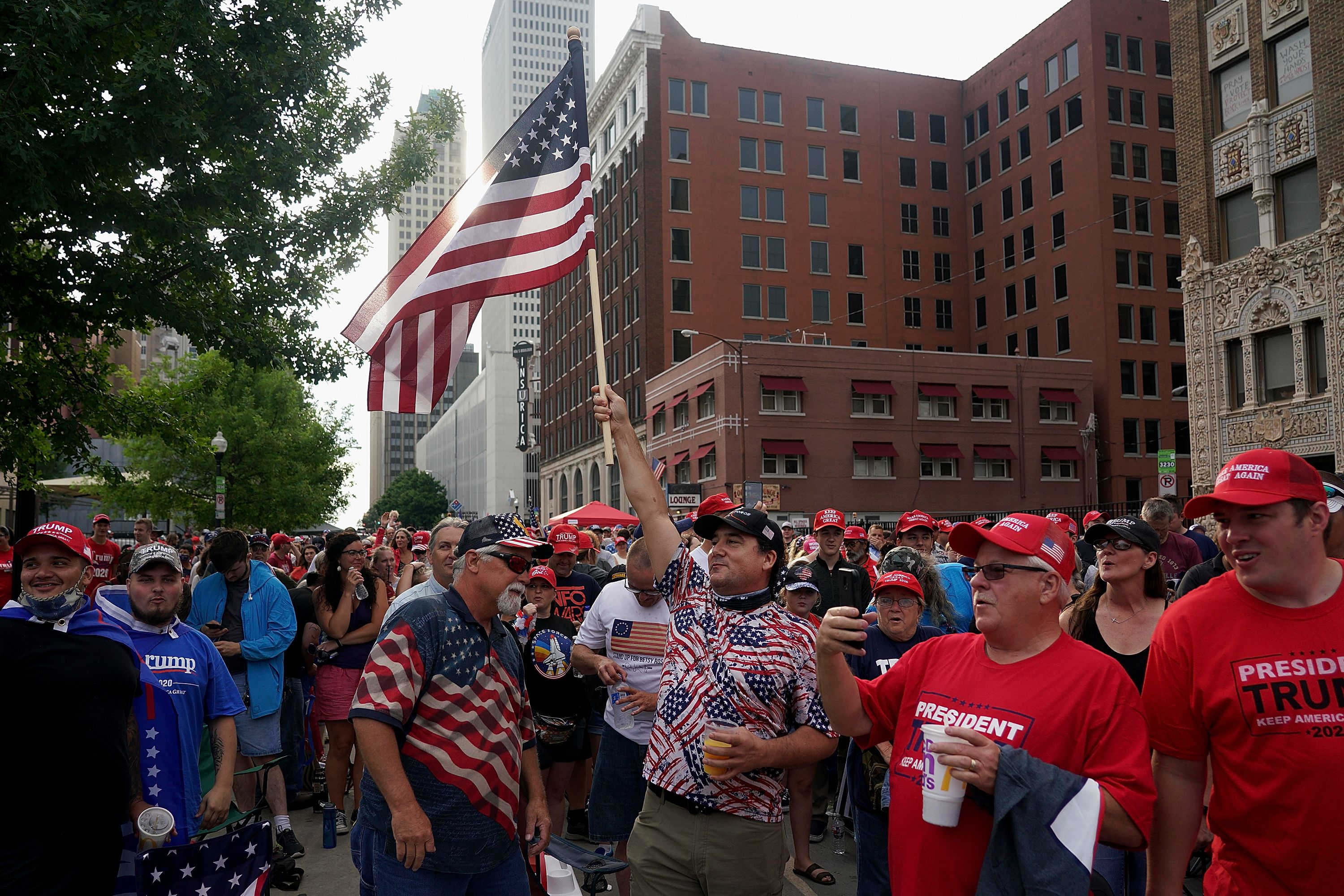 A man holds an American flag above a crowd
