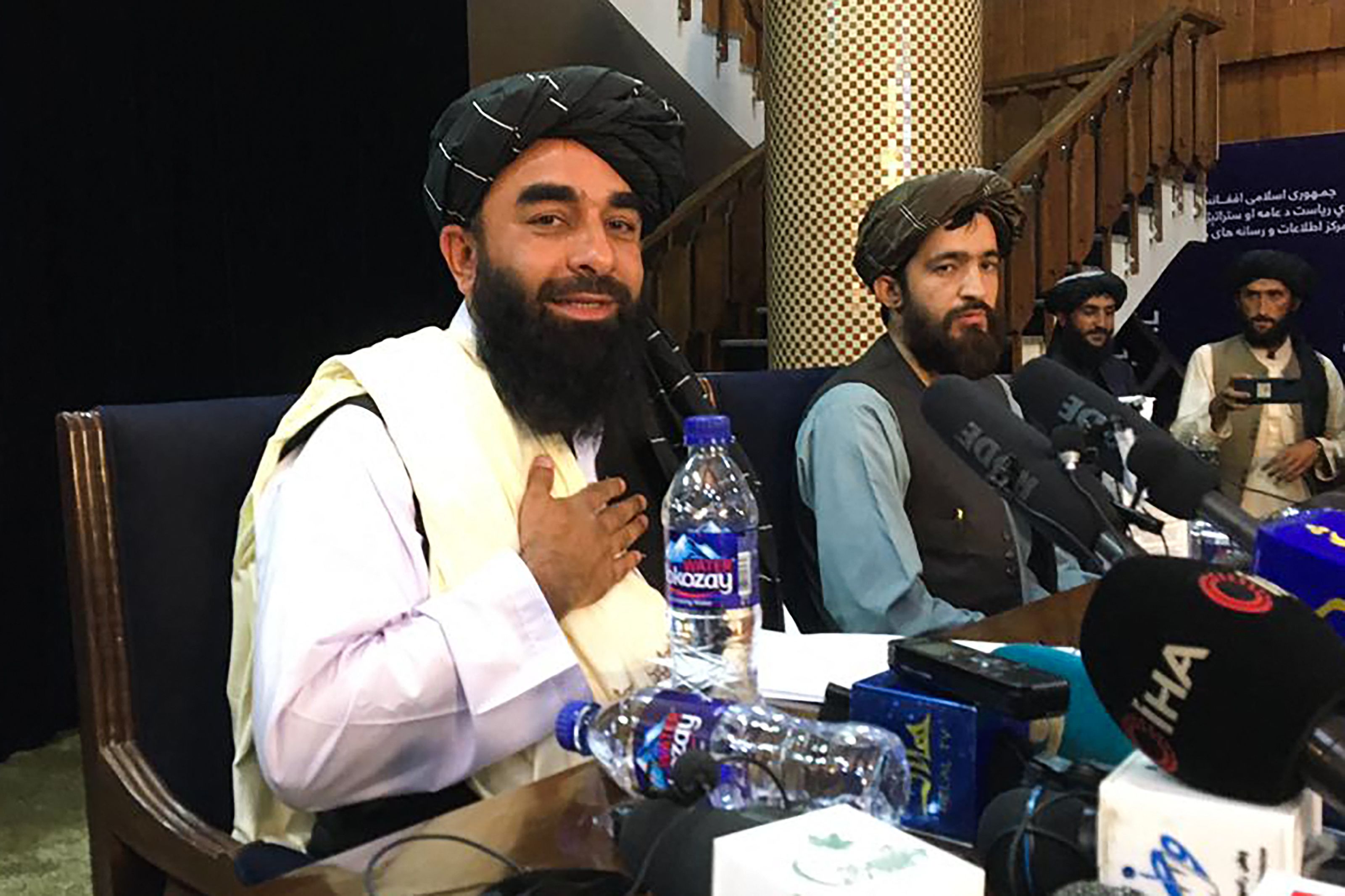 Taliban spokesperson Zabihullah Mujahid (L) attends the first press conference in Kabul on August 17