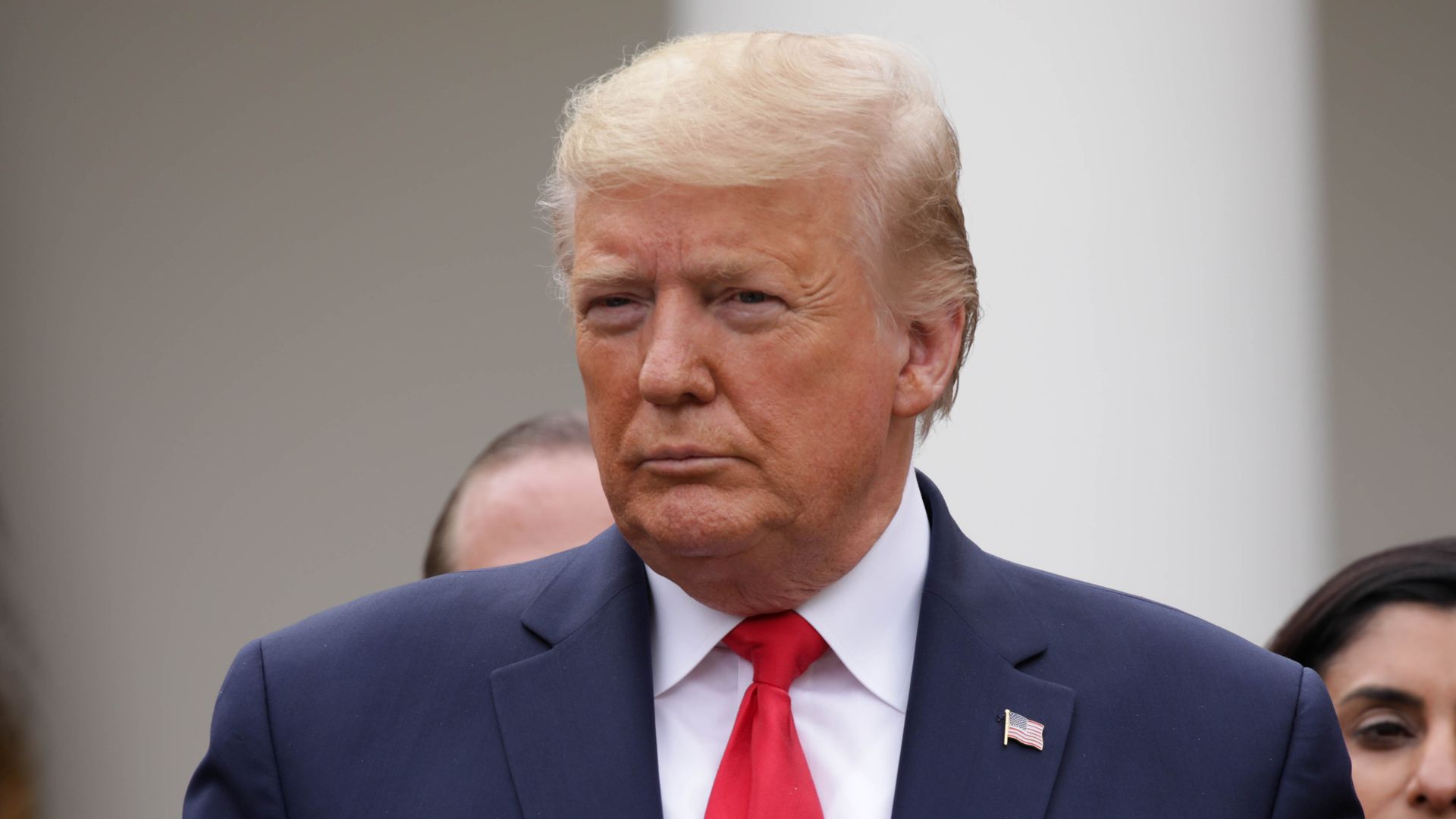 In this image, Trump stands while wearing a tie