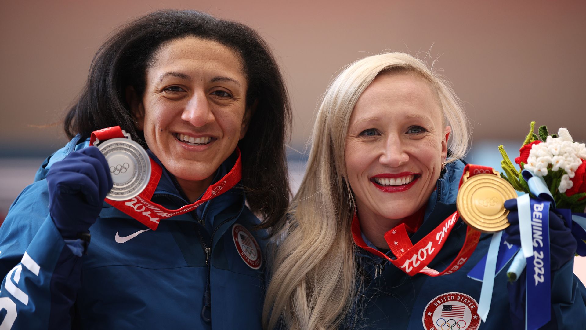 Team USA's Elana Meyers Taylor and Kaillie Humphries hug while holding up their silver and gold Olympic medals. 