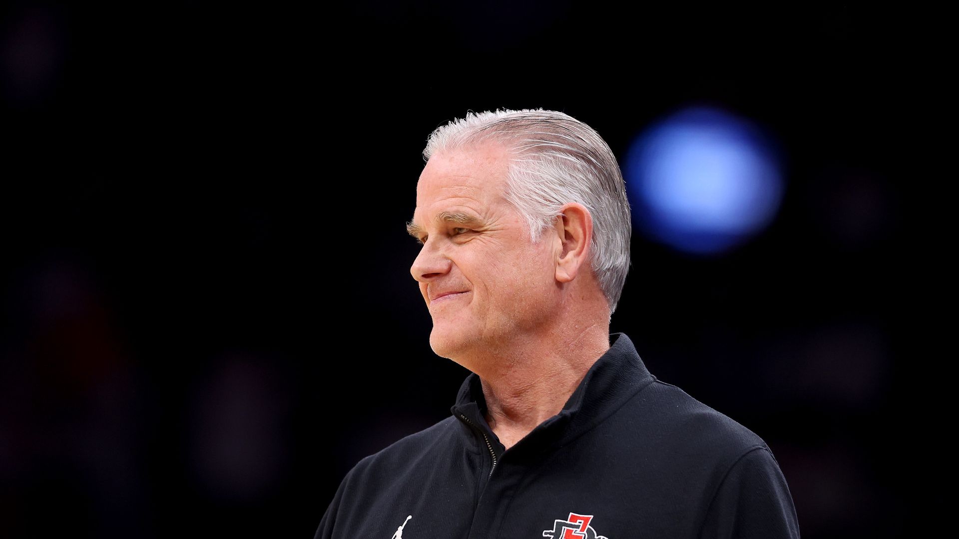 A white man in a black shirt smiling