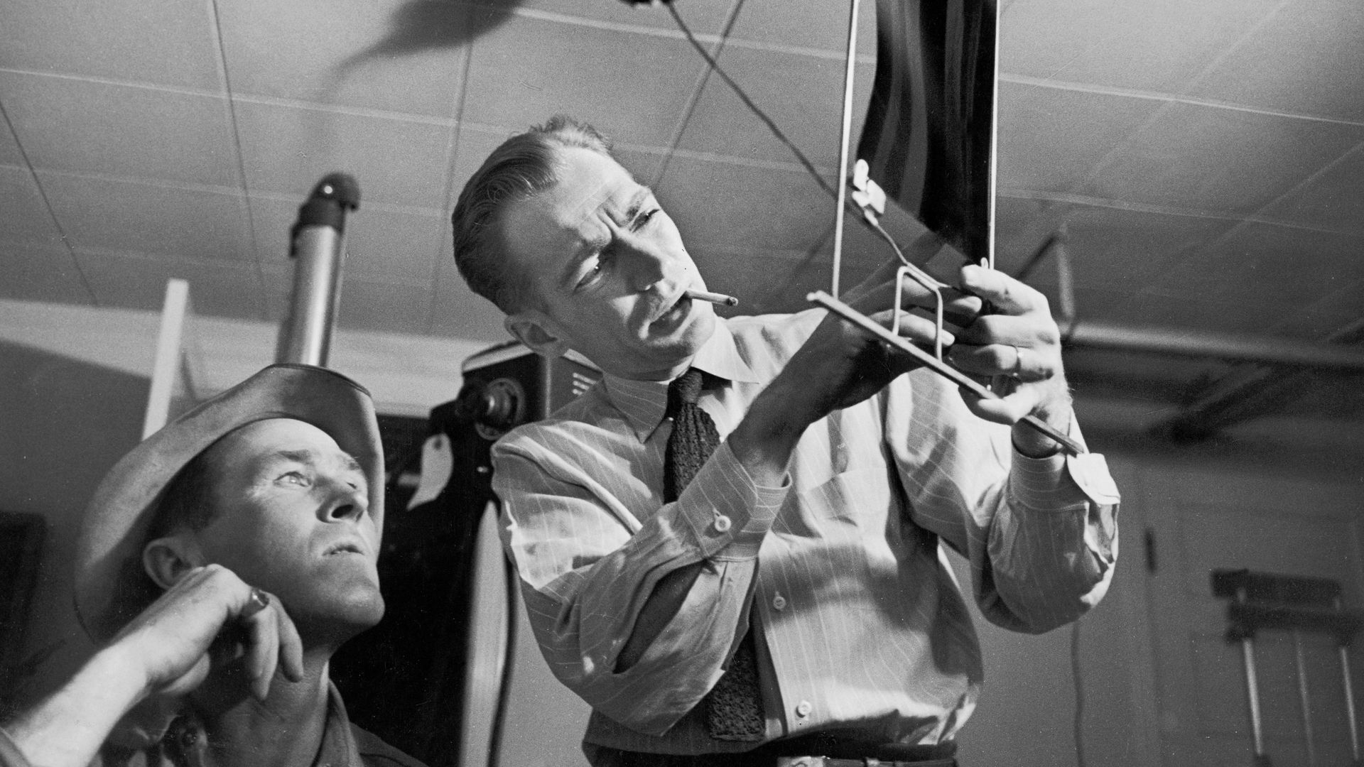 Black and white photo of a doctor pointing at an x-ray image