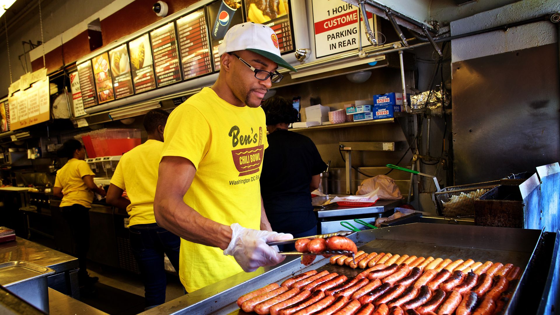 A man grilling half-smokes at Ben's Chili Bowl in DC