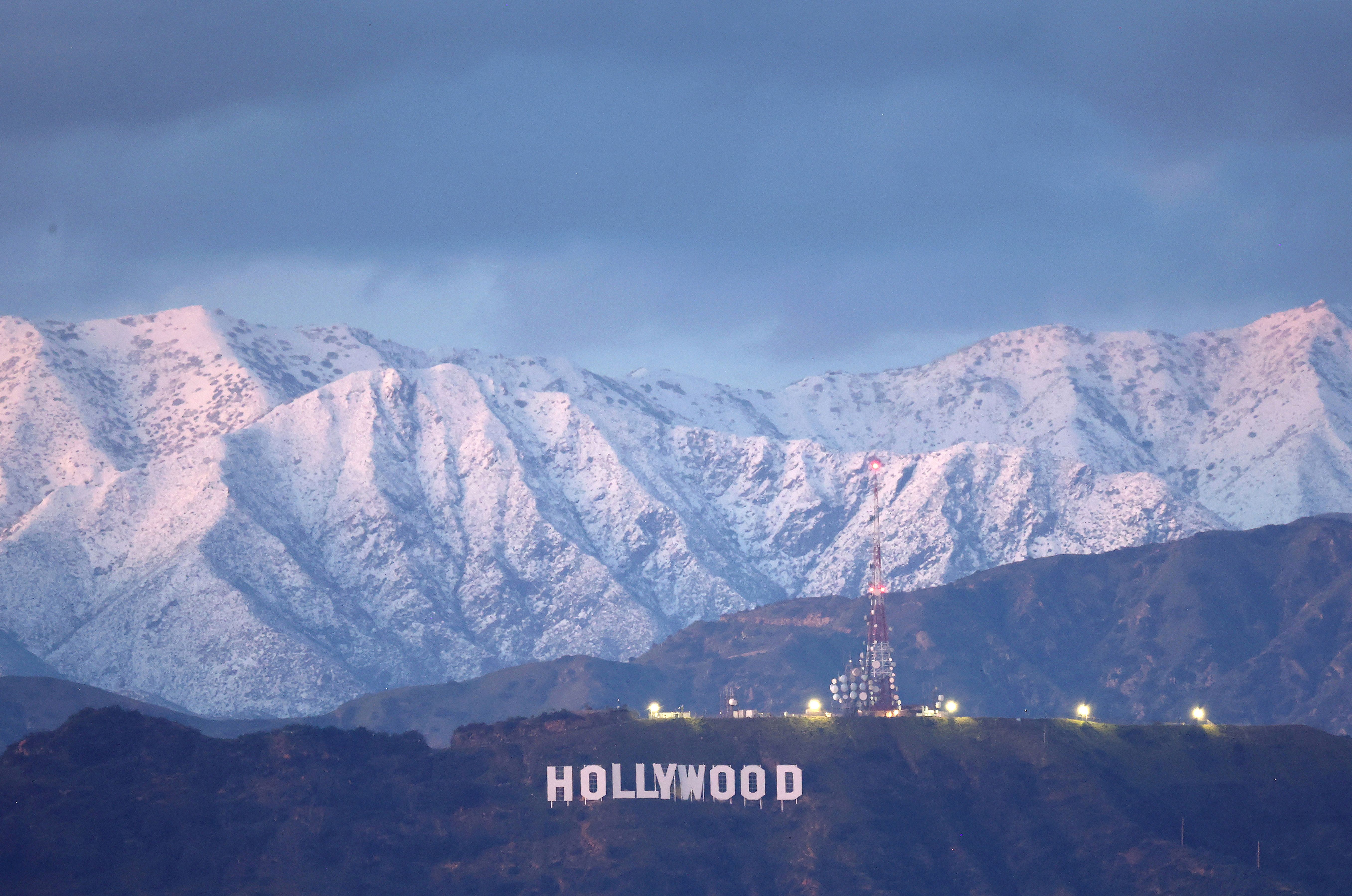 The Hollywood sign stands in front of snow-covered mountains after another winter storm hit Southern California on March 01, 2023 in Los Angeles.