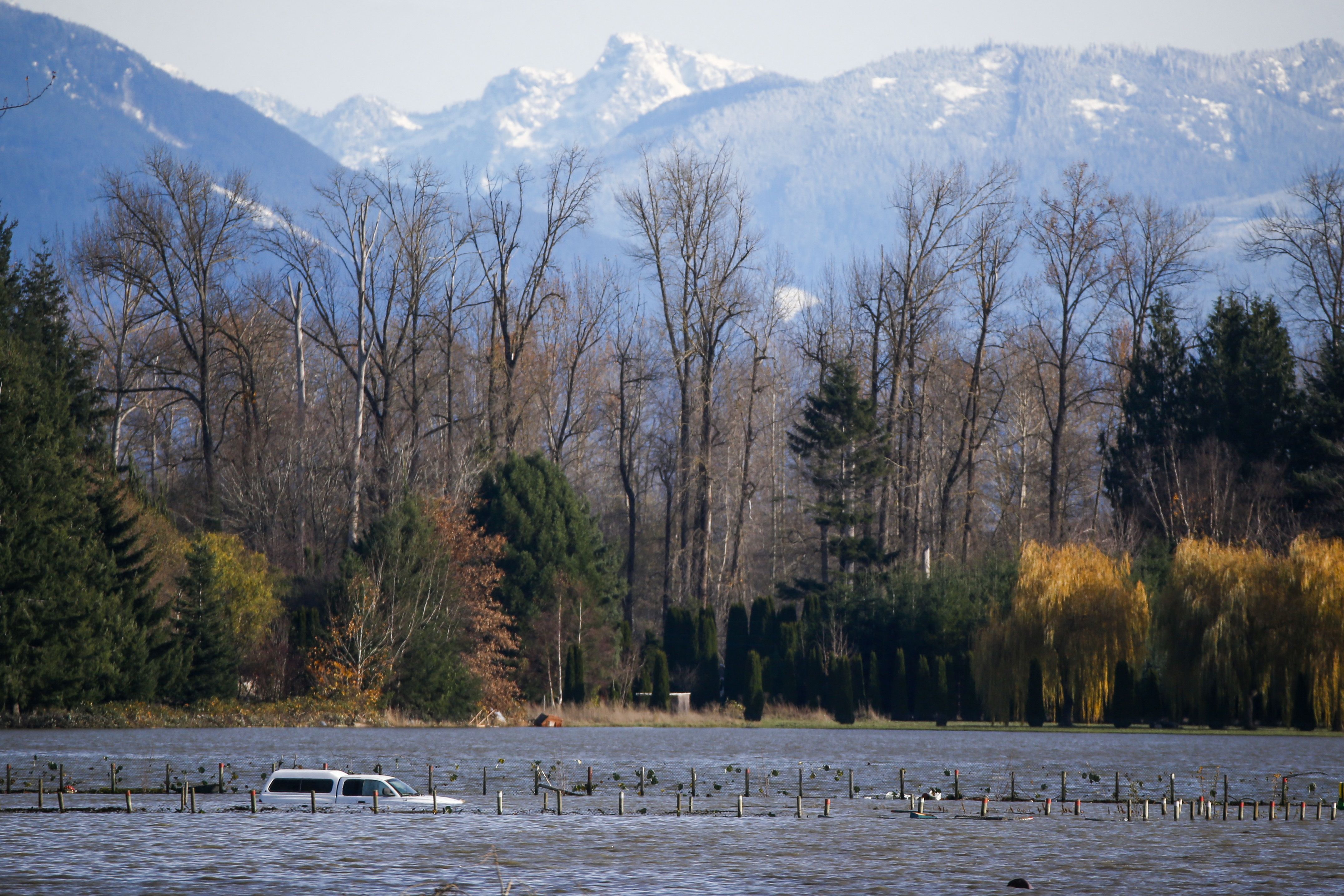  A car is seen partially submerged as floodwaters from the Skagit River inundate farmland outside of Burlington, Washington, on November 17
