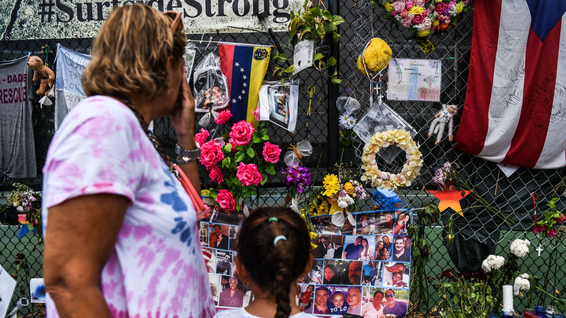 A woman cries as she visits a makeshift memorial where the partially collapsed Champlain Towers South building stood in Surfside, Florida