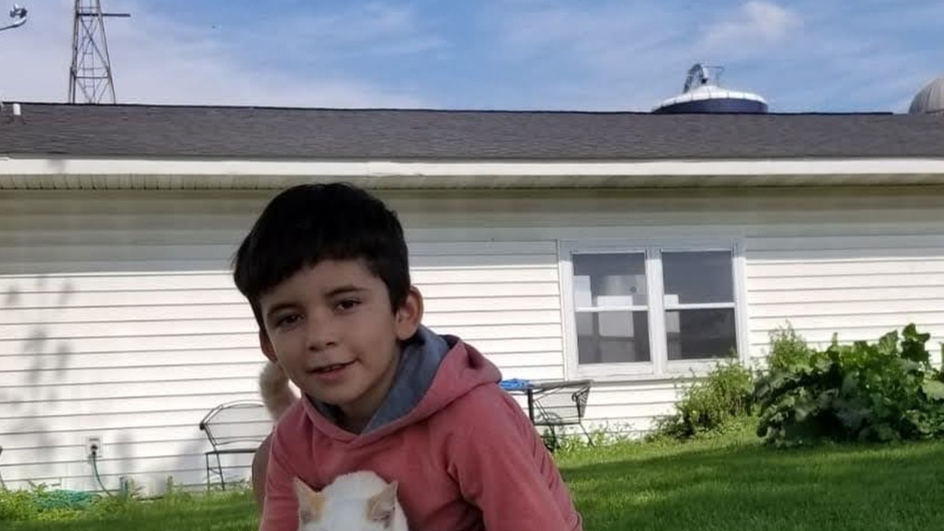 Jefferson Rodríguez at D&K Dairy in Dane, Wisconsin holds a cat.