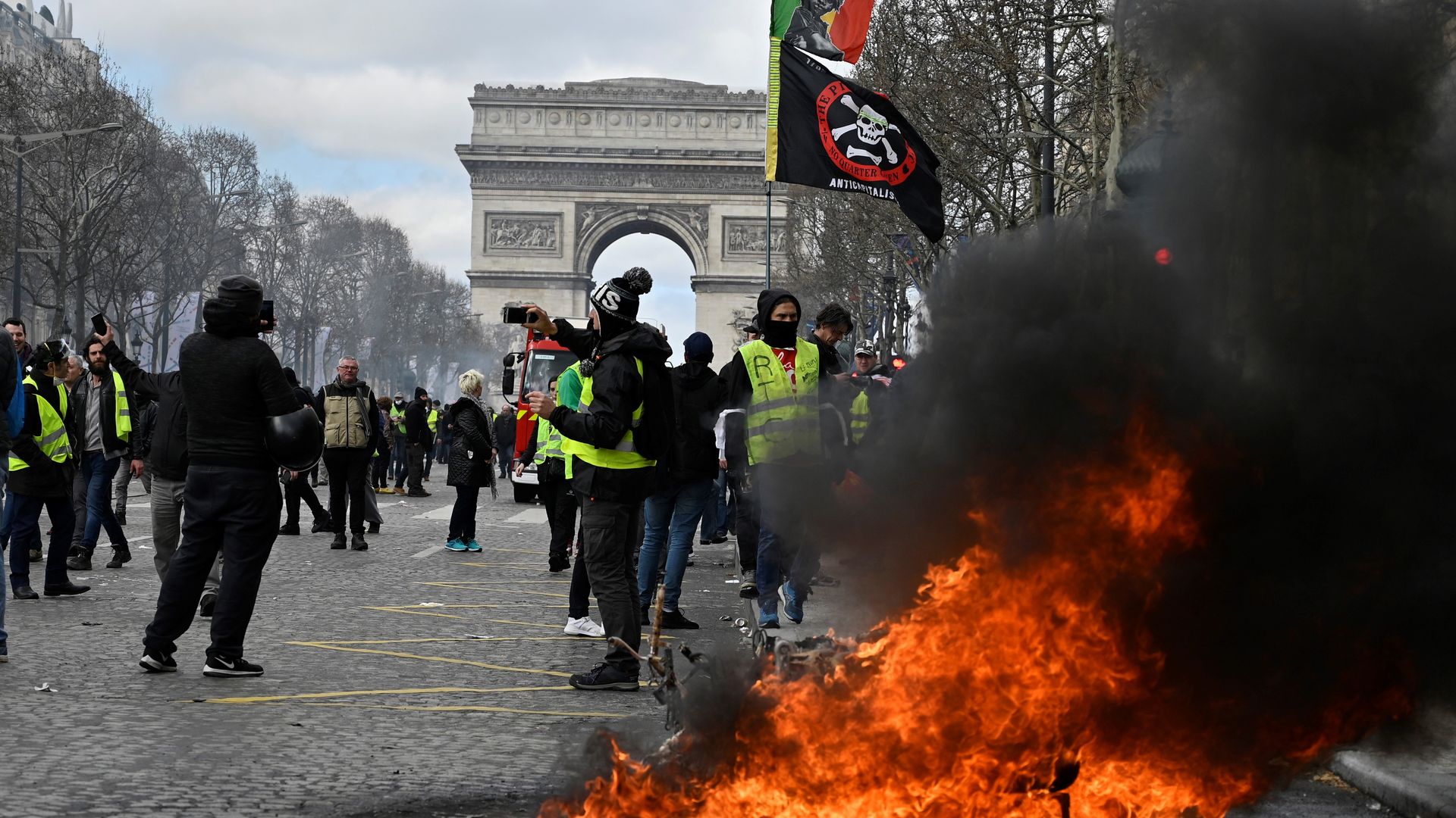 Arc de Triomphe in background, fire in foreground.