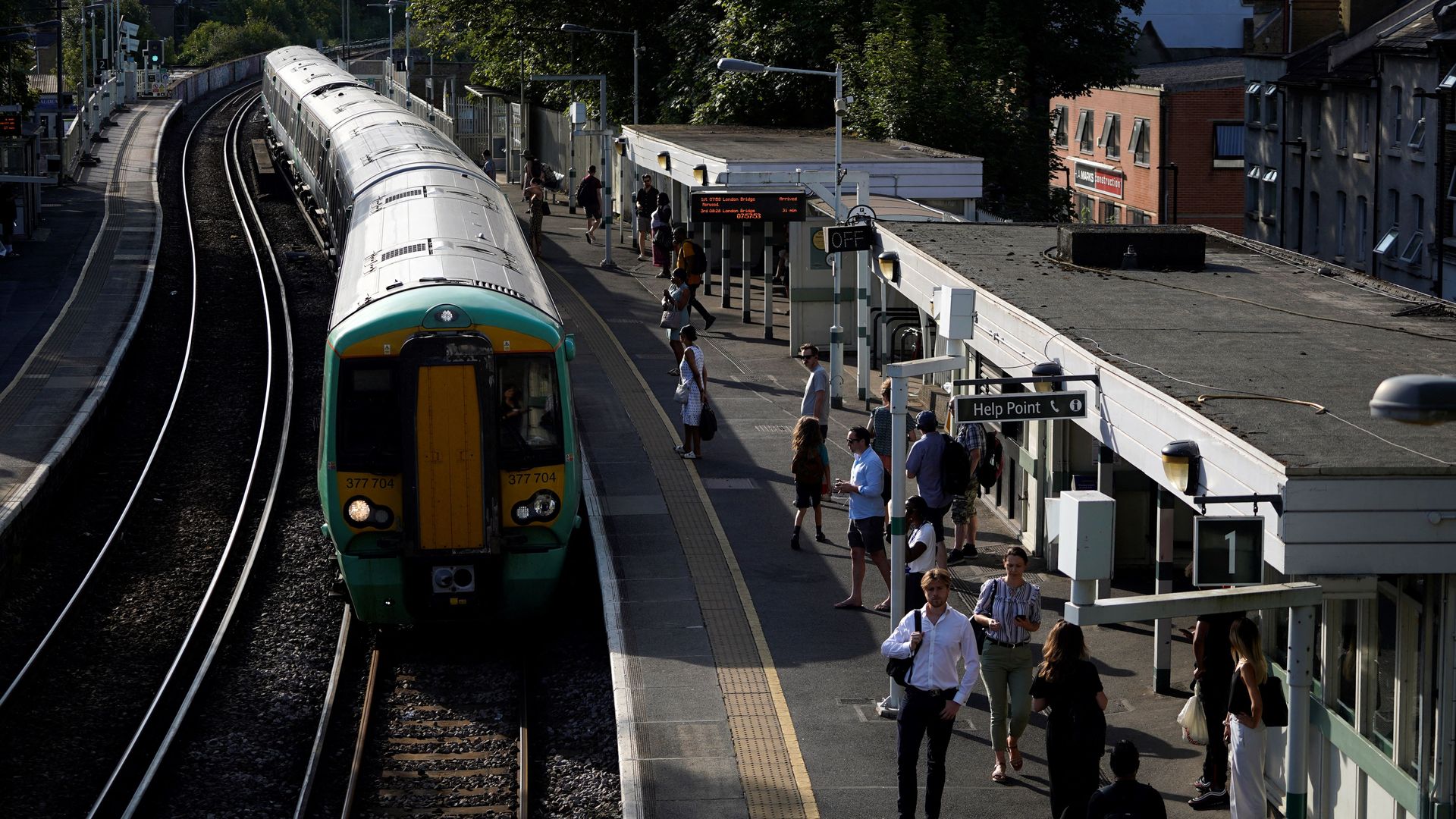 Commuters wait for their train on a platform at West Norwood station in south London on July 18.