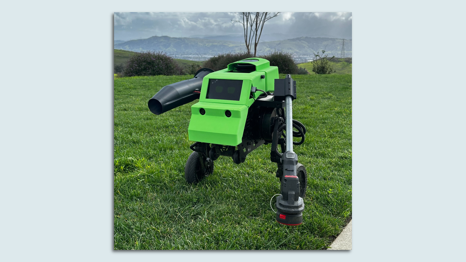 A robot lawn mower is shown in a field of grass.