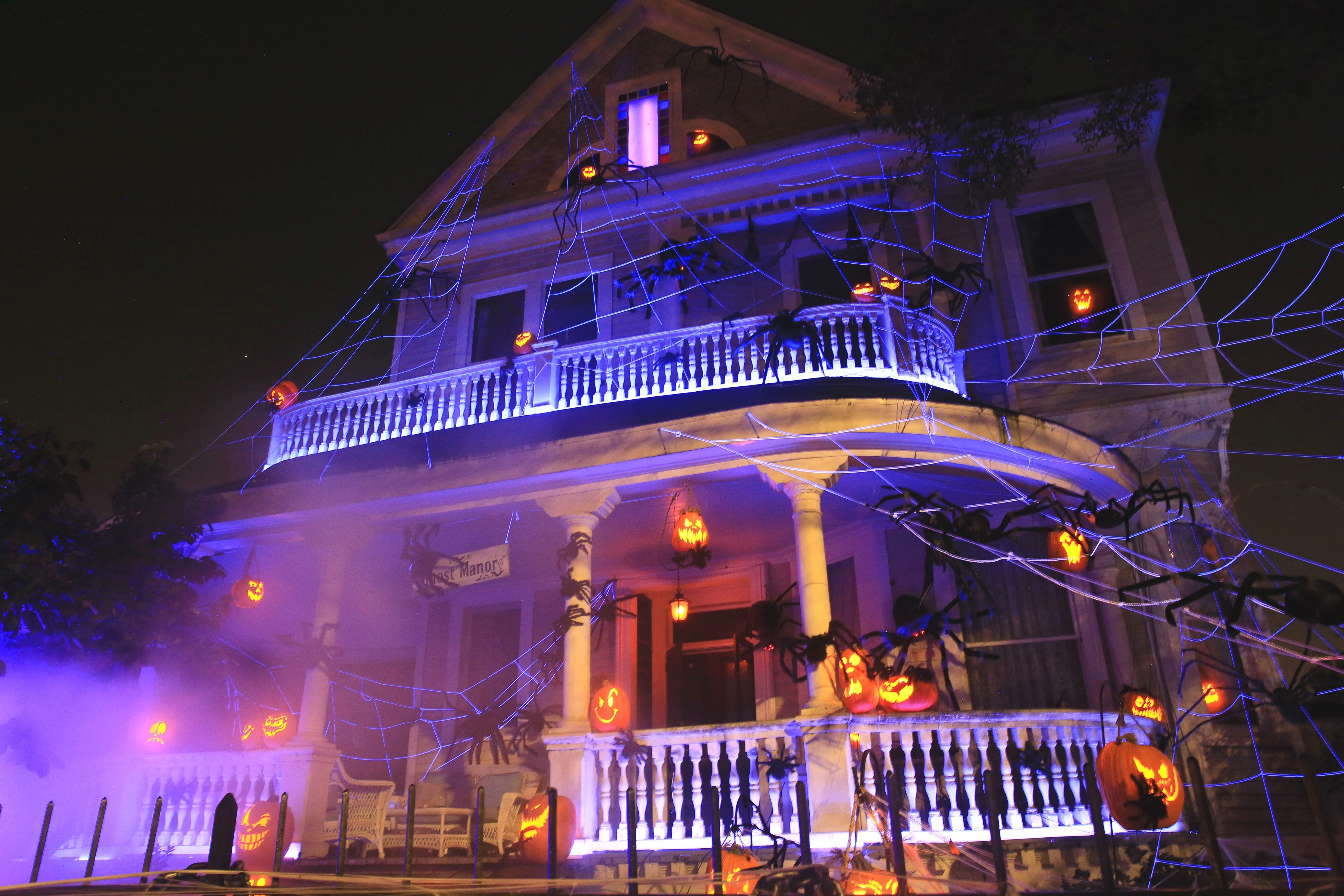 Ghost Manor is seen fully decorated at night with jack-o-lanterns and cobwebs, and smoke fills the air.