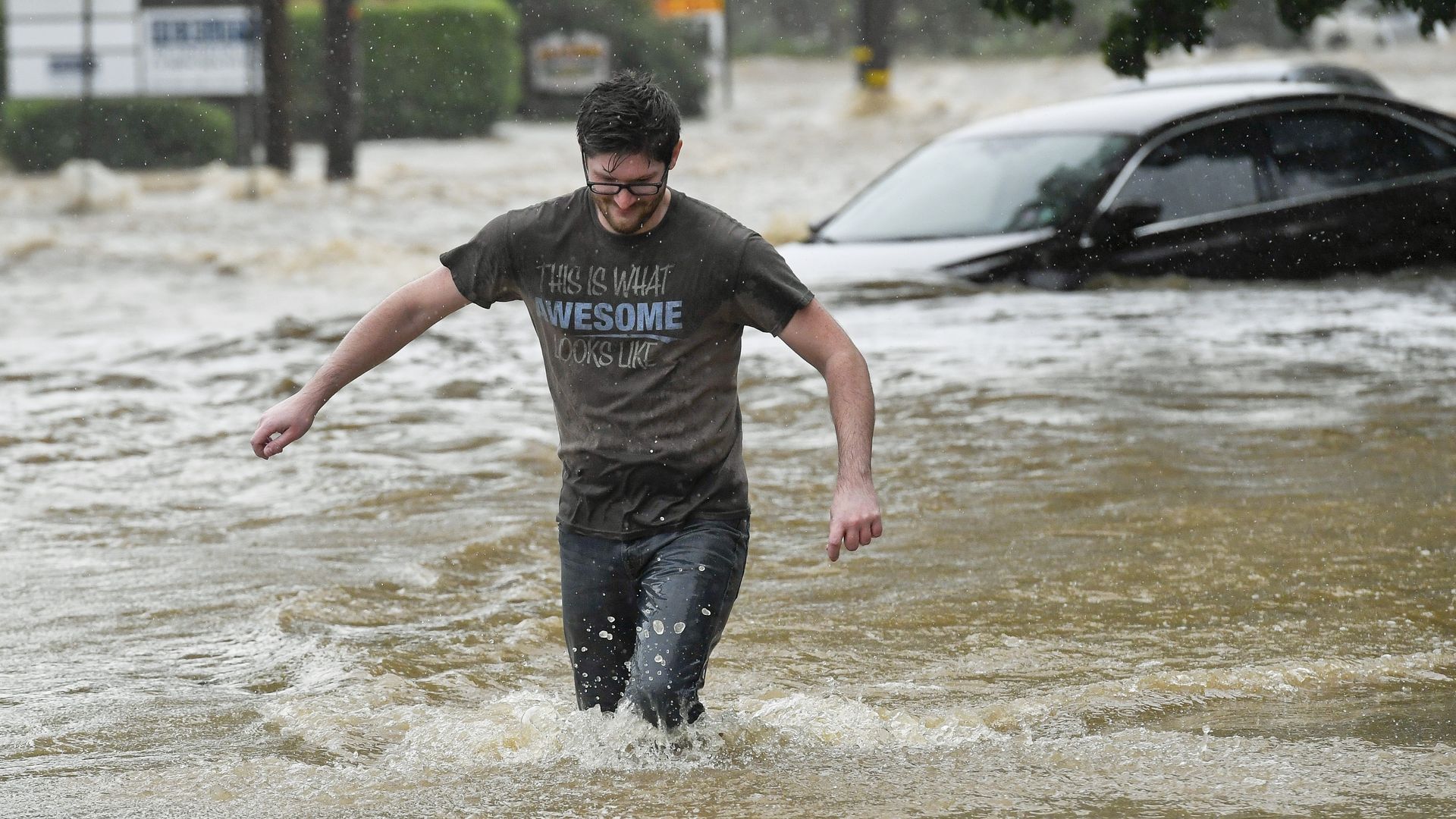 A man walks through floodwaters In Muhlenberg Township where heavy rains and flooding hit Berks County Pennsylvania as a result of tropical storm Isaias moved along the East Coast Tuesday August 4