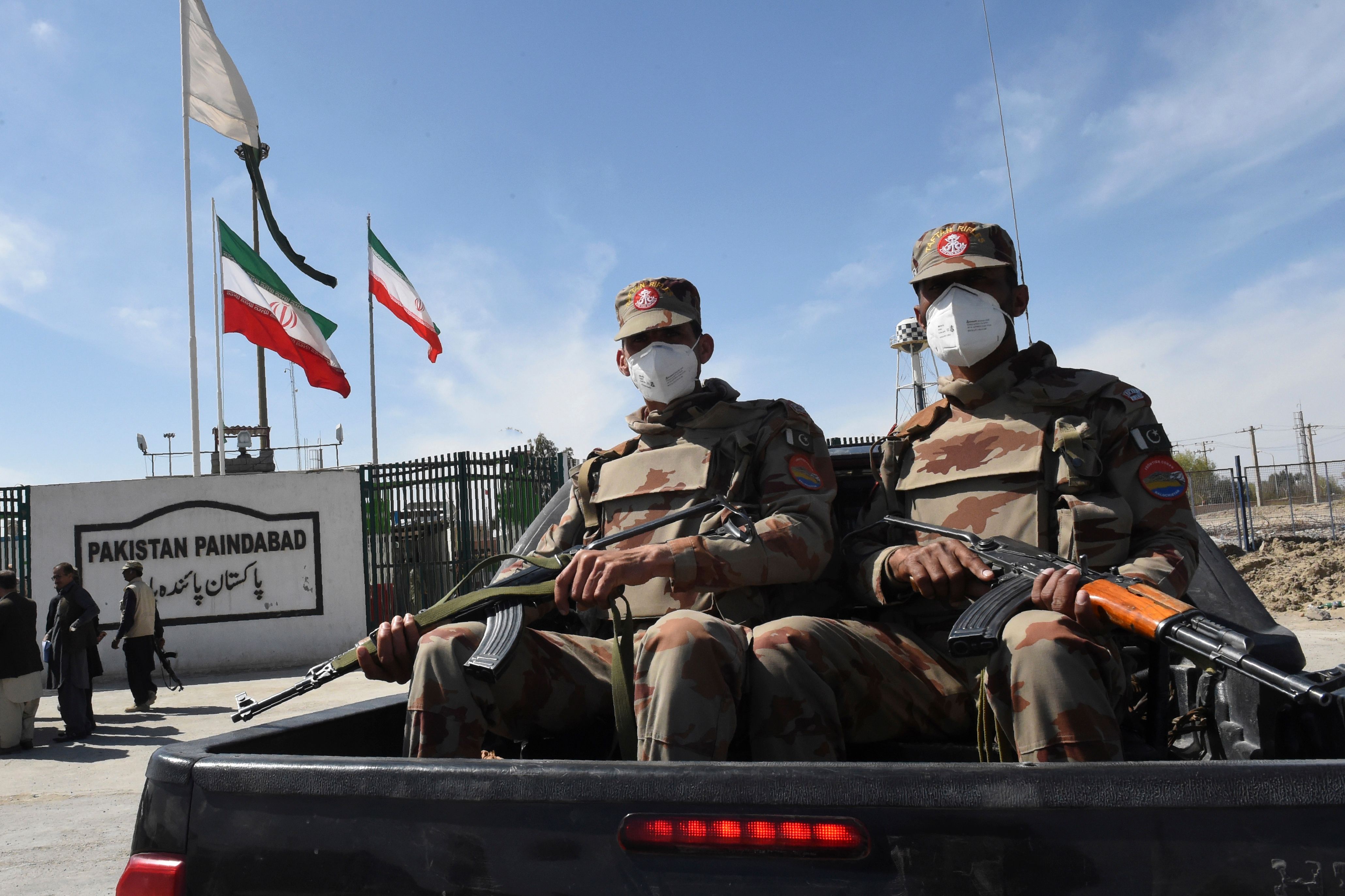 Pakistani soldiers wearing facemasks patrol near the closed Pakistan-Iran border in Taftan on February 25
