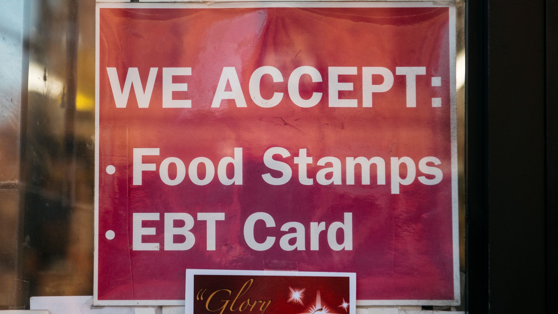A sign about SNAP food stamp benefits is posted on a cooler door inside a Brooklyn grocery store.