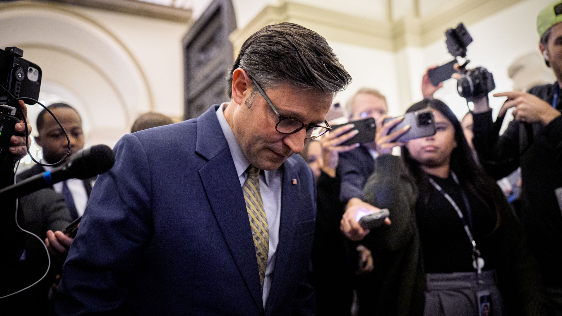 House Speaker Mike Johnson at the Capitol, surrounded by reporters