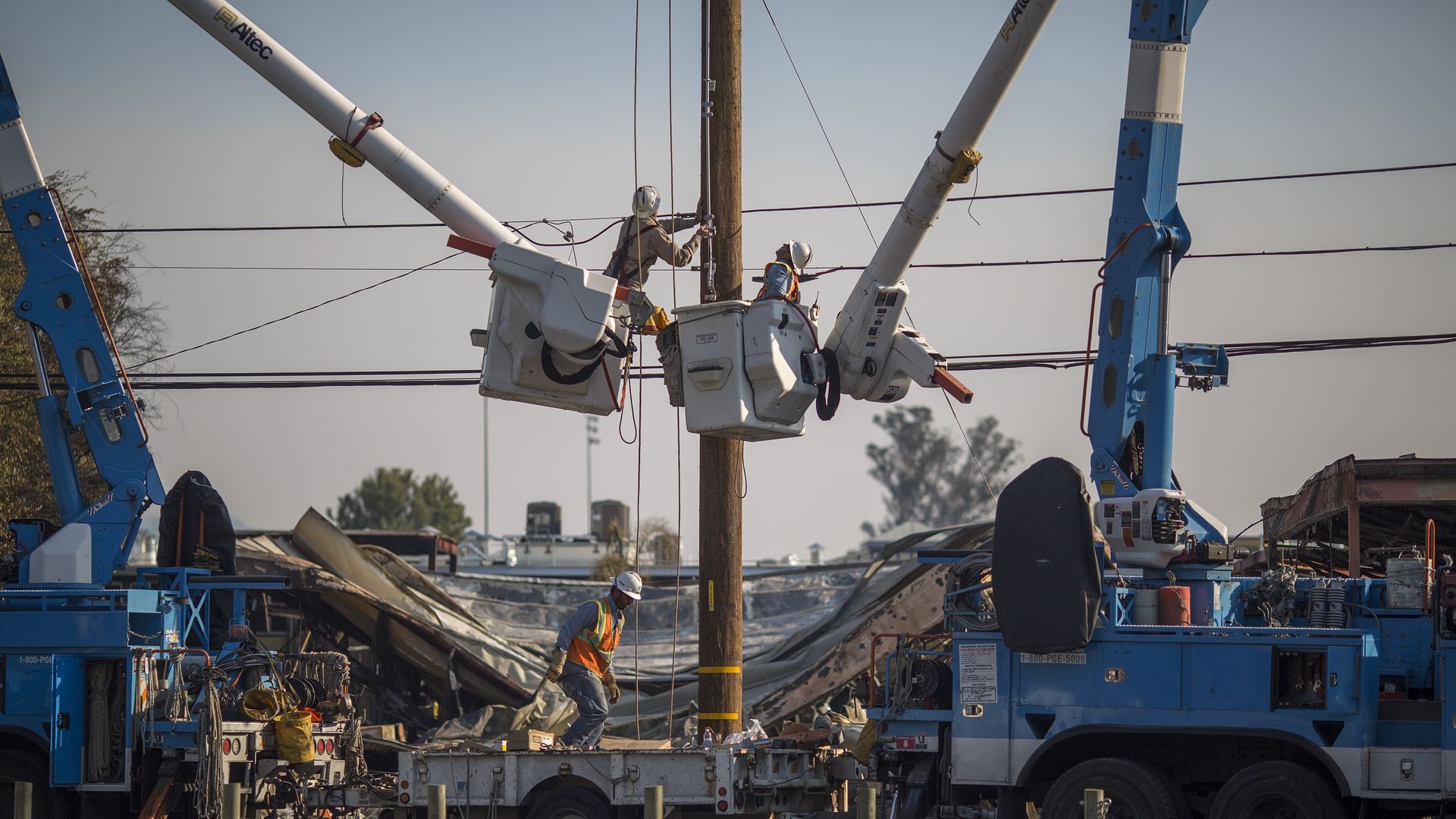 Pacific Gas and Electric Company crews work to restore power near fire-damaged Cardinal Newman High School on October 14, 2017 in Santa Rosa, California.