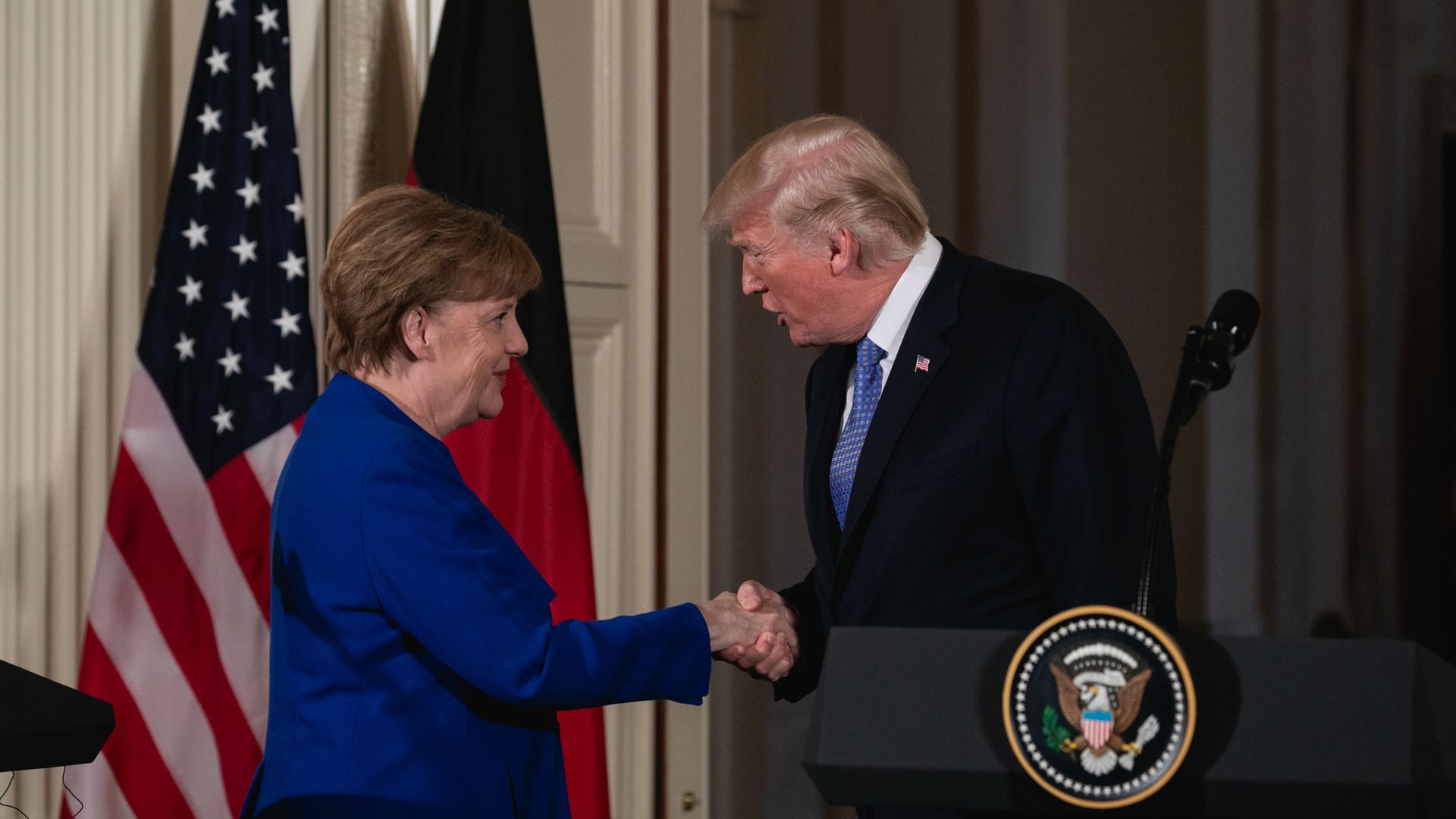 Donald Trump shakes German Chancellor Angela Merkel's hand during a meeting in Washington
