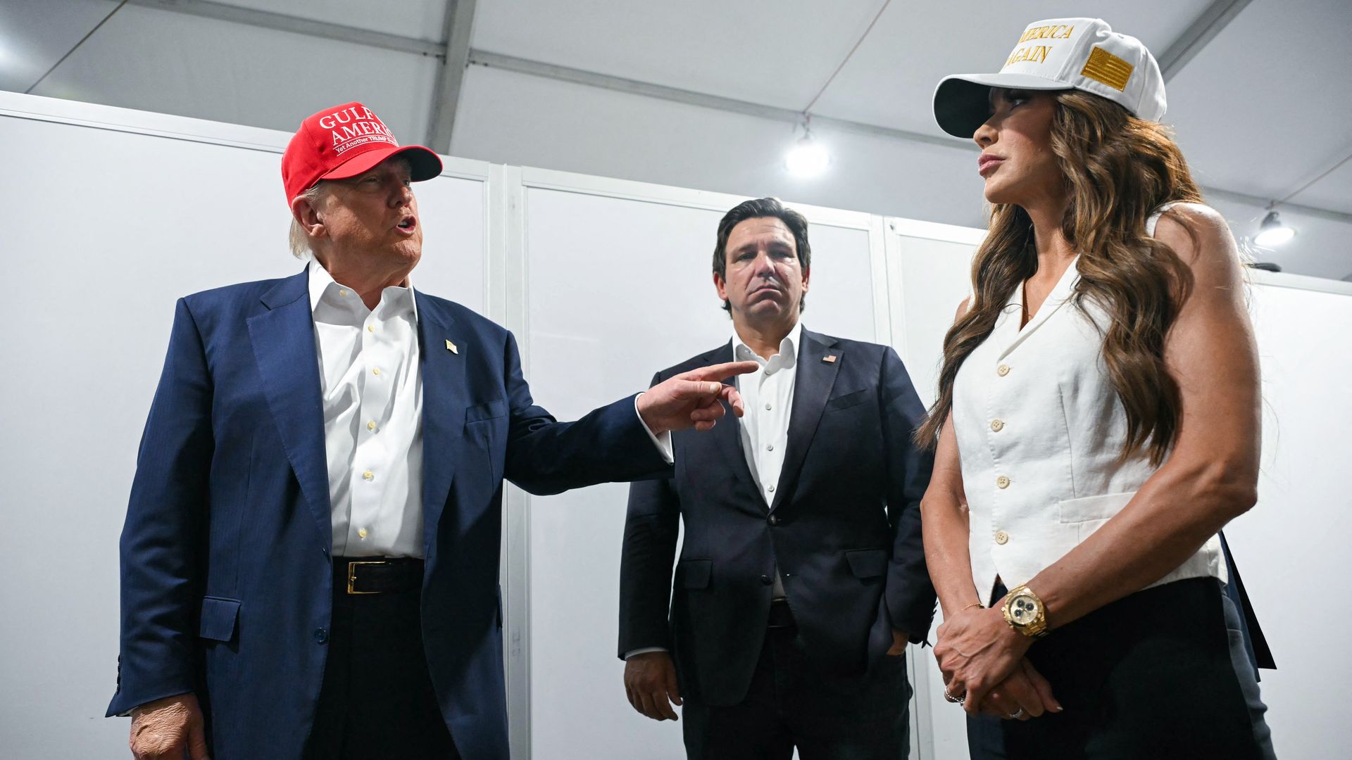 President Trump points as Kristi Noem and Ron DeSantis look on.
