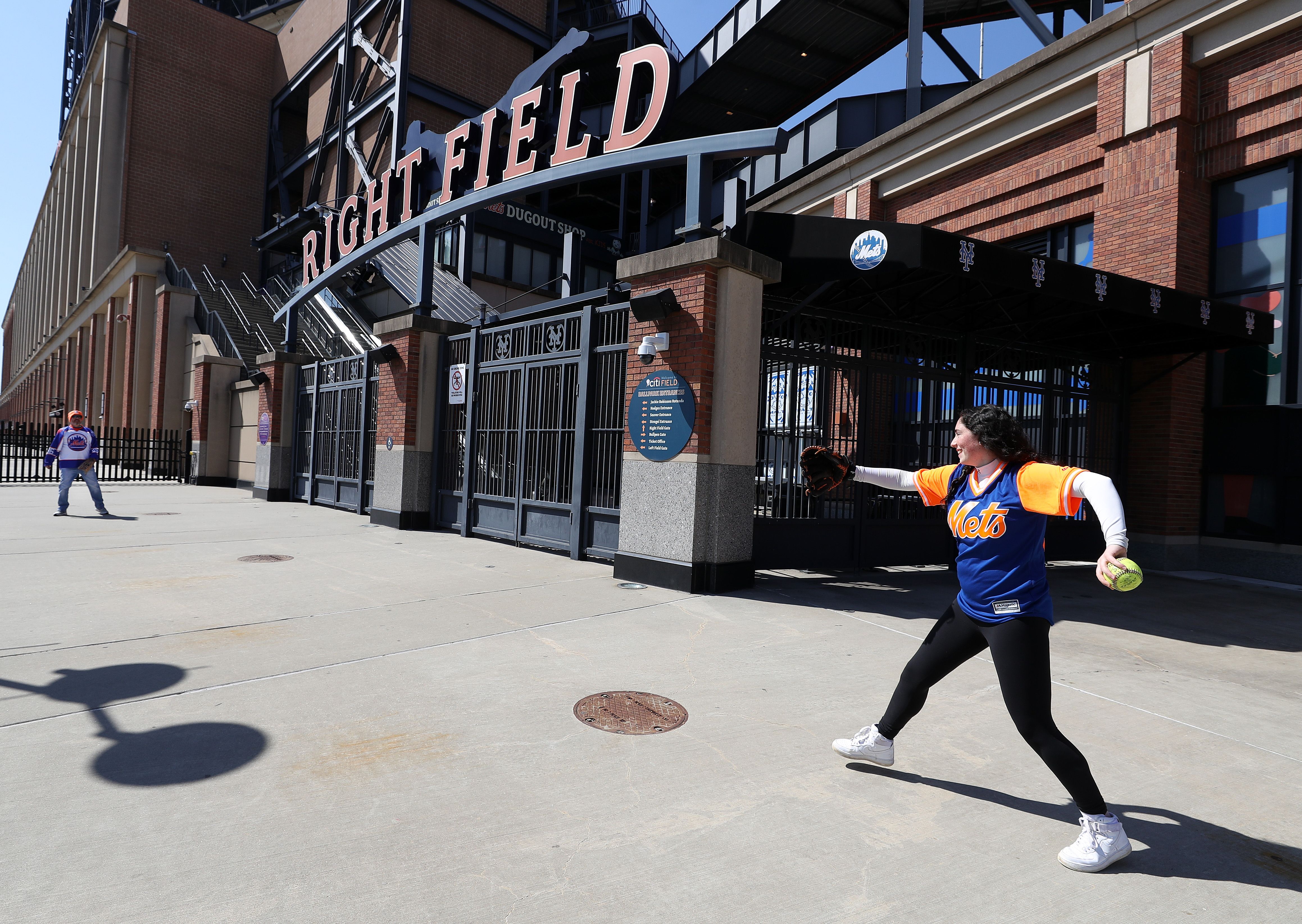 Father and daughter playing catch outside Citi Field