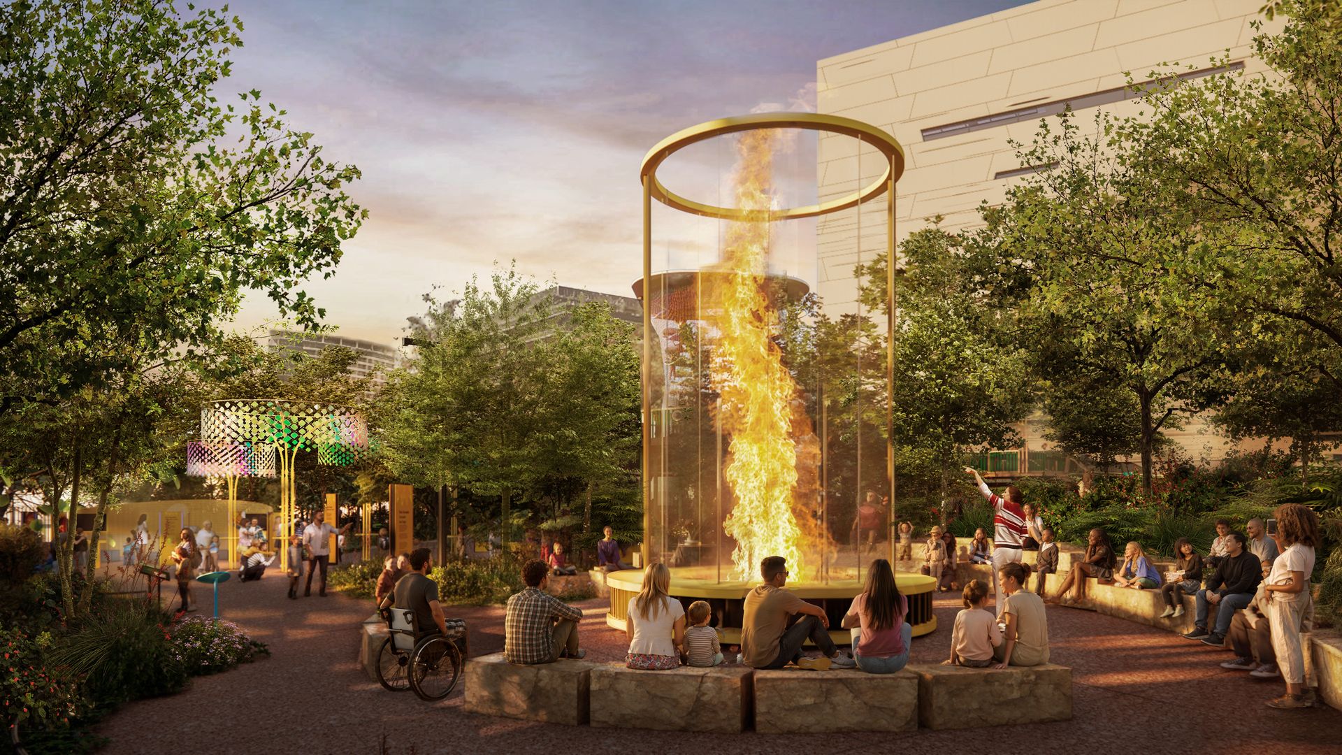 Sunset at a modern plaza featuring a tall glass flame cylinder ringed by a gold circle; people sit around the fiery pillar among trees and a pale building in the background.