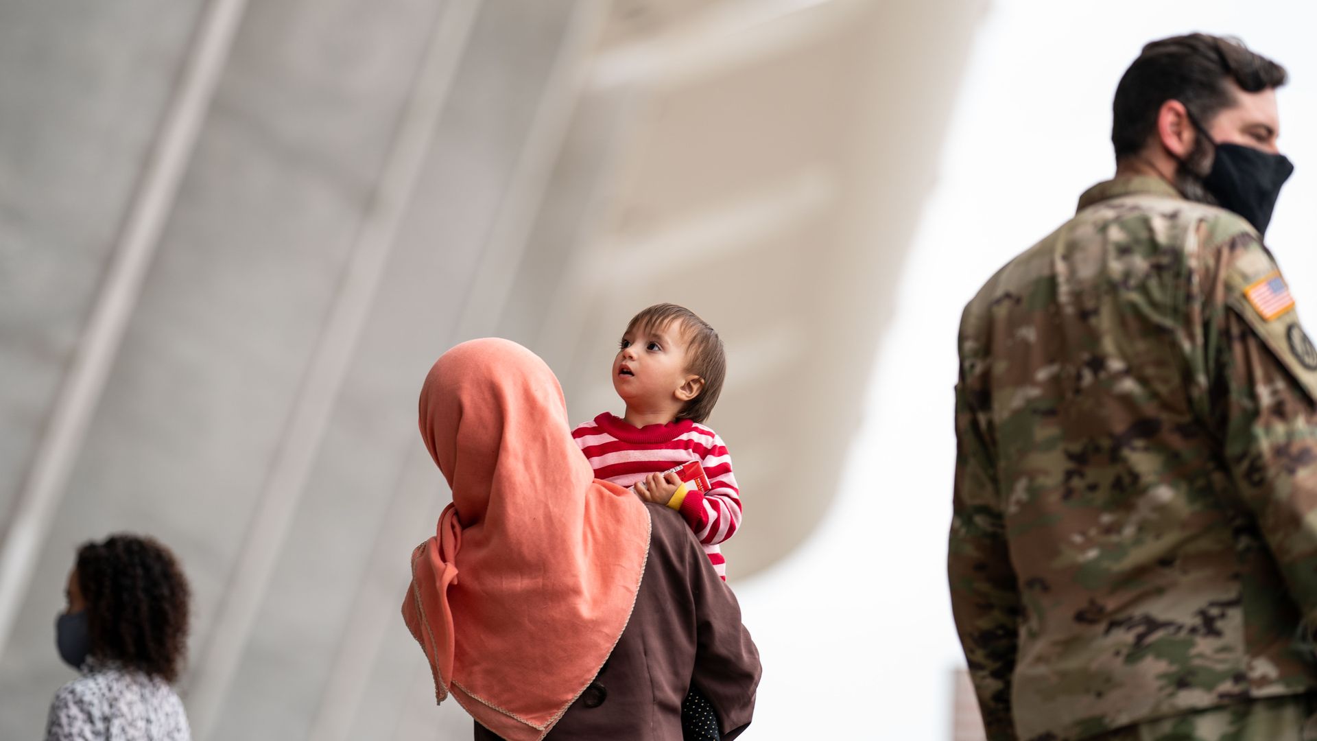 A Afghan woman holds a toddler outside Dulles International Airport.