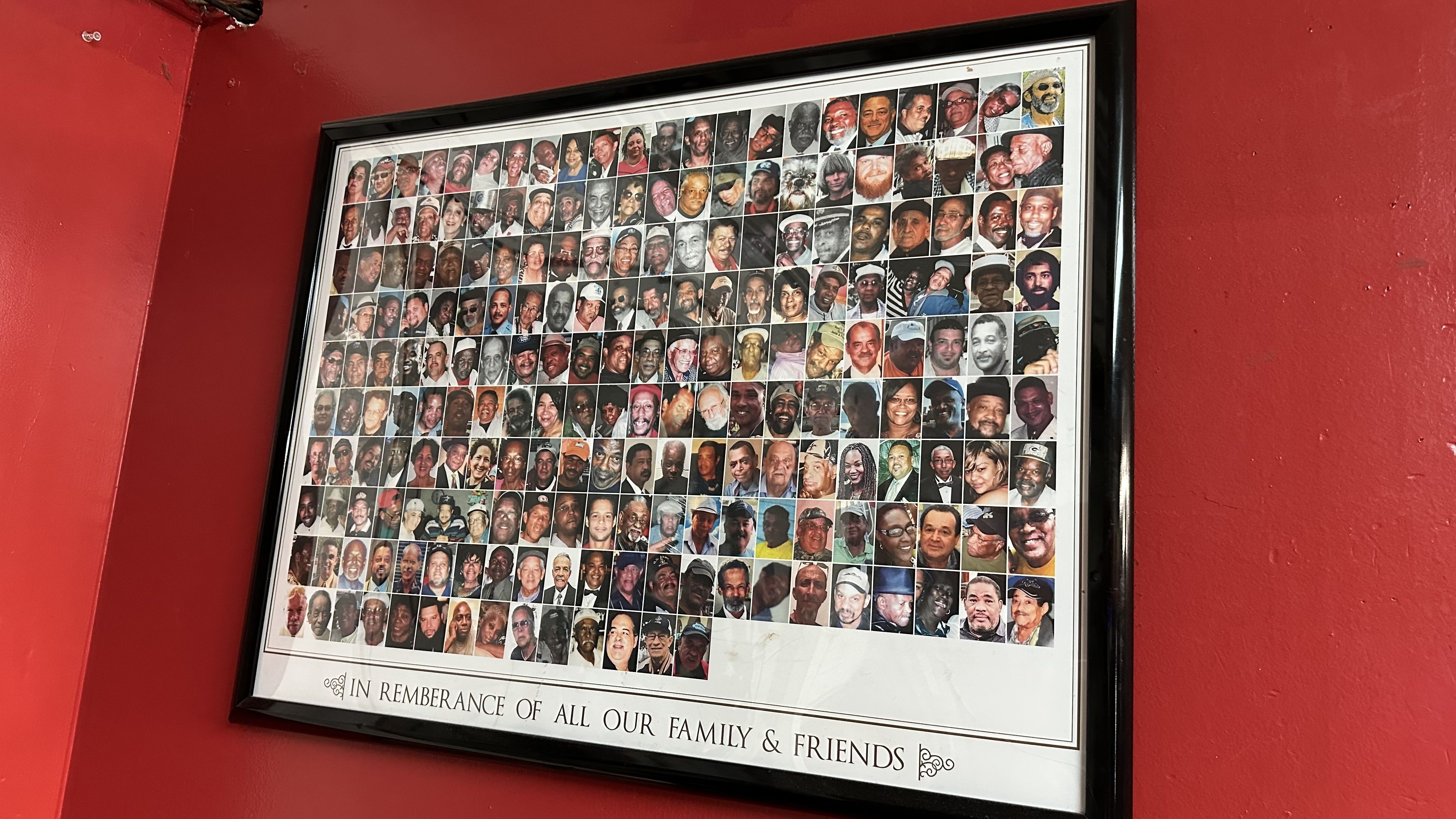 A photo of a poster that says "In remembrance of our family and friends" with dozens of small photos of people.