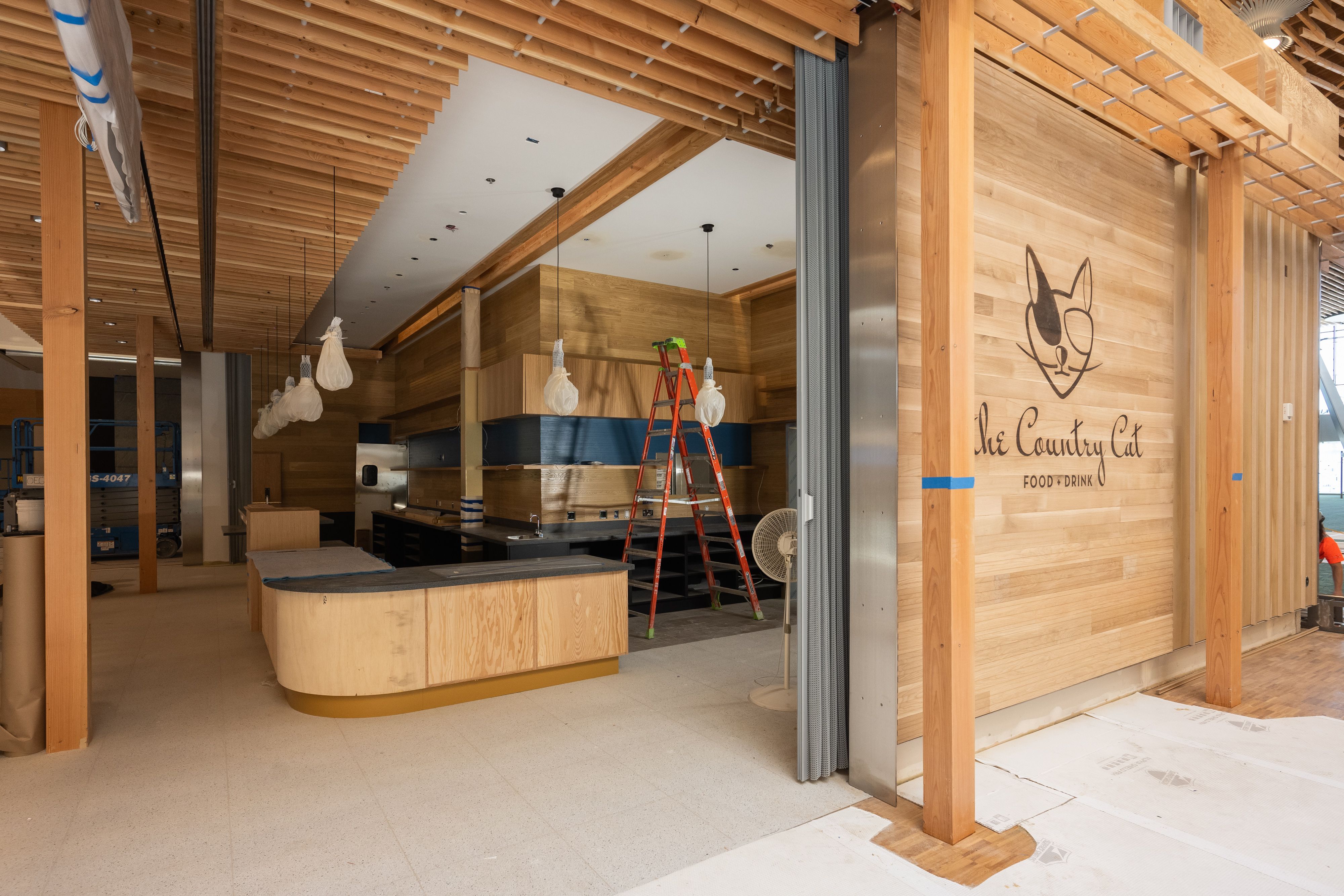 A photo of a storefront inside an airport with wooden signage that reads "The Country Cat"