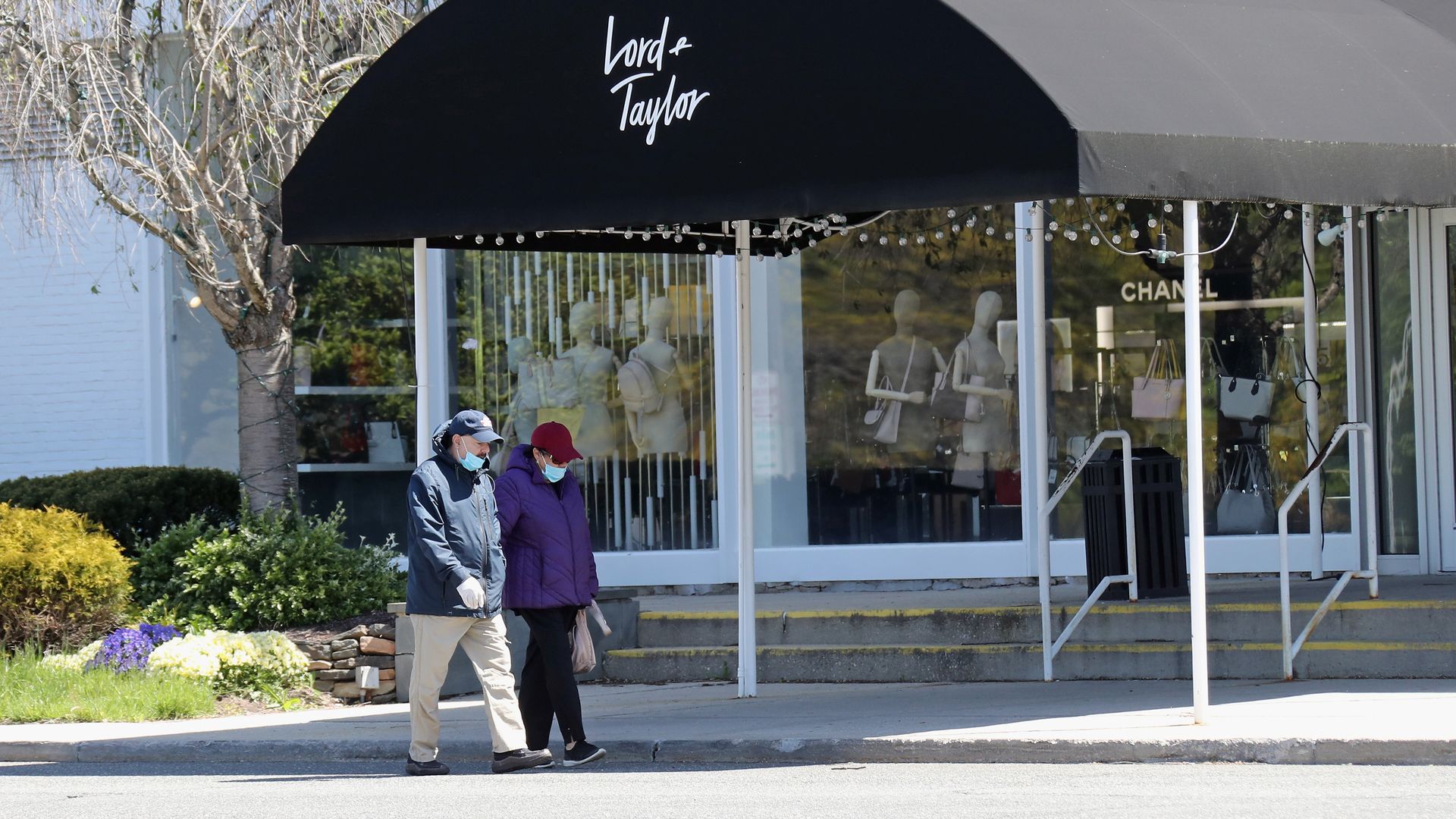 Pedestrians walk past a shuttered Lord and Taylor department store following their filing for bankruptcy amid the COVID-19 pandemic on May 12, 2020 in Garden City, New York. 