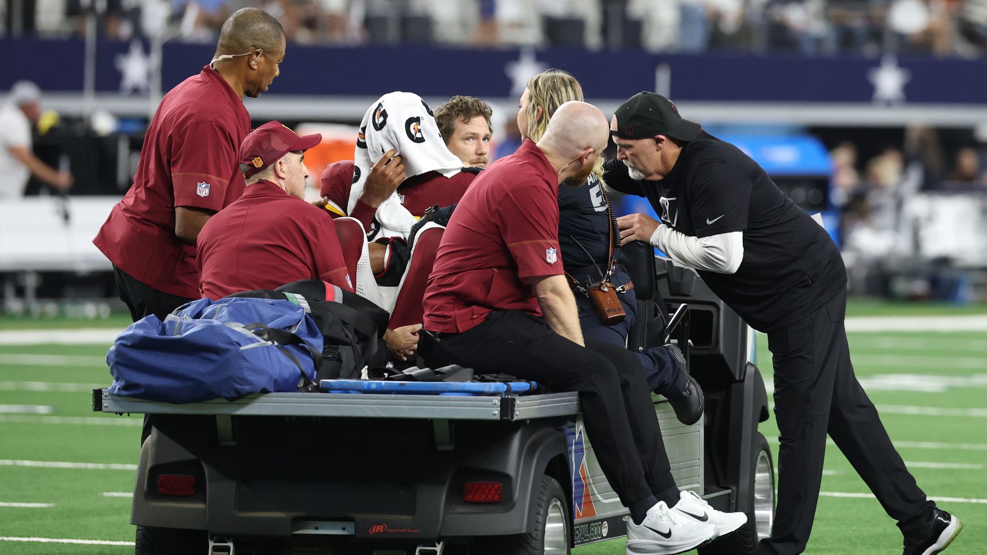 An injured Jayden Daniels leaves the field in a cart vehicle