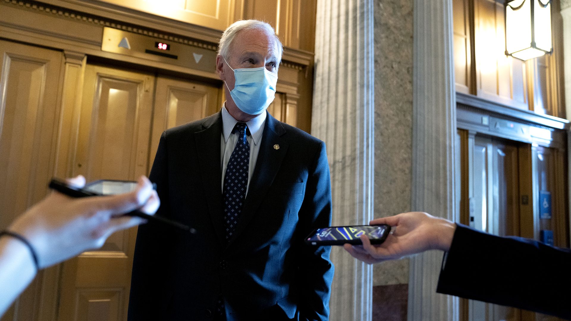 Sen. Ron Johnson is seen speaking with a pair of reporters.