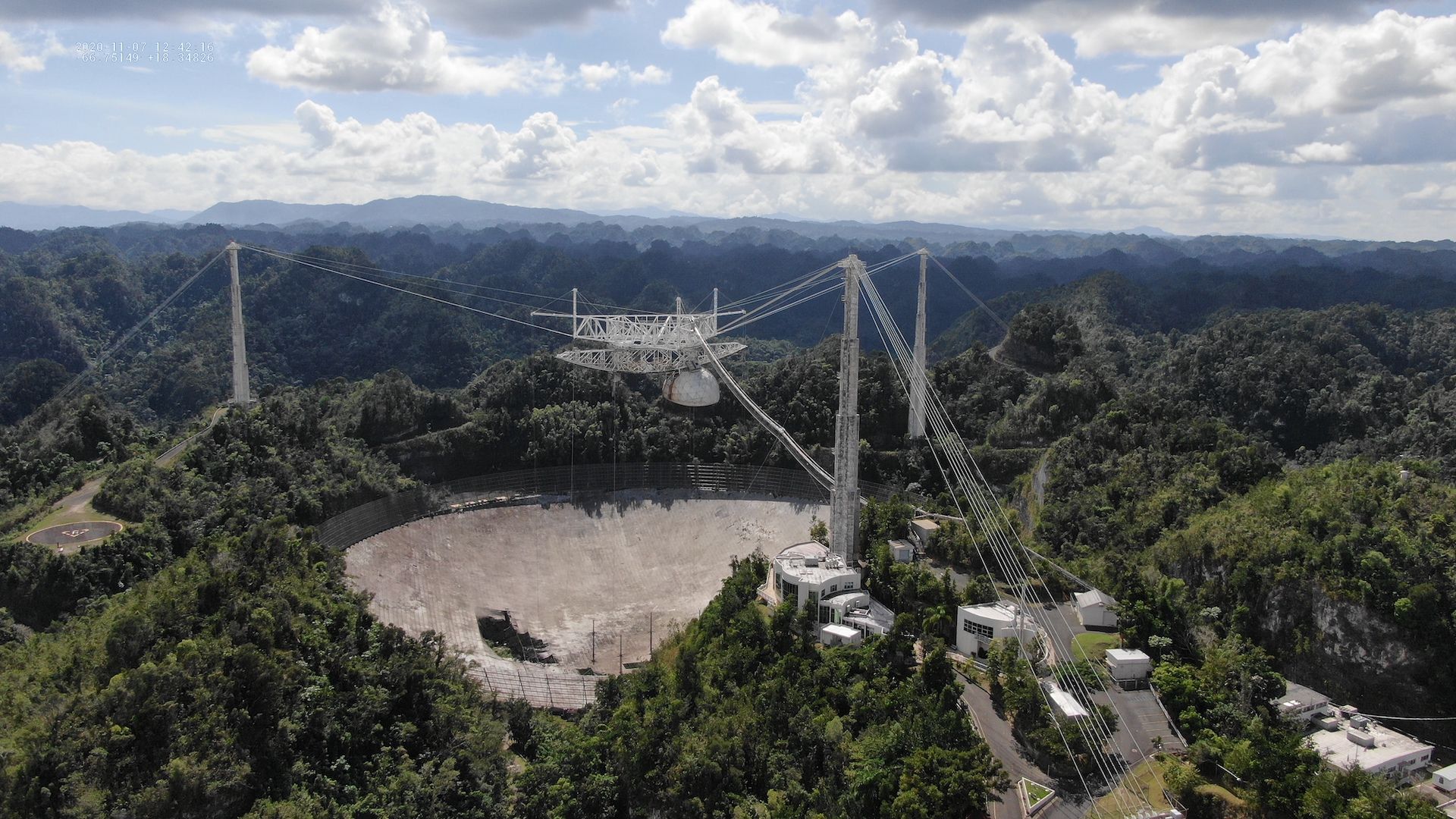 The damaged Arecibo Observatory in Puerto Rico. A telescope dish with a hole in the middle of it.