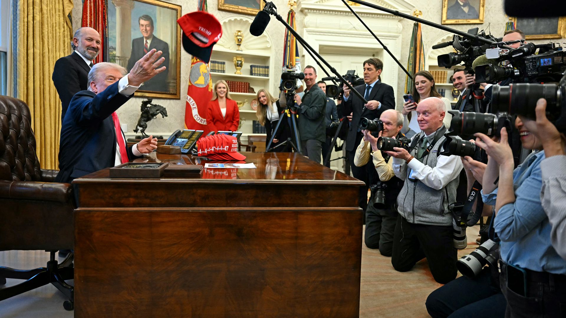 President Trump tosses a hat reading "Trump was right about everything" toward the press pool after signing an executive order in the Oval Office yesterday. Photo: Jim Watson/AFP via Getty Images