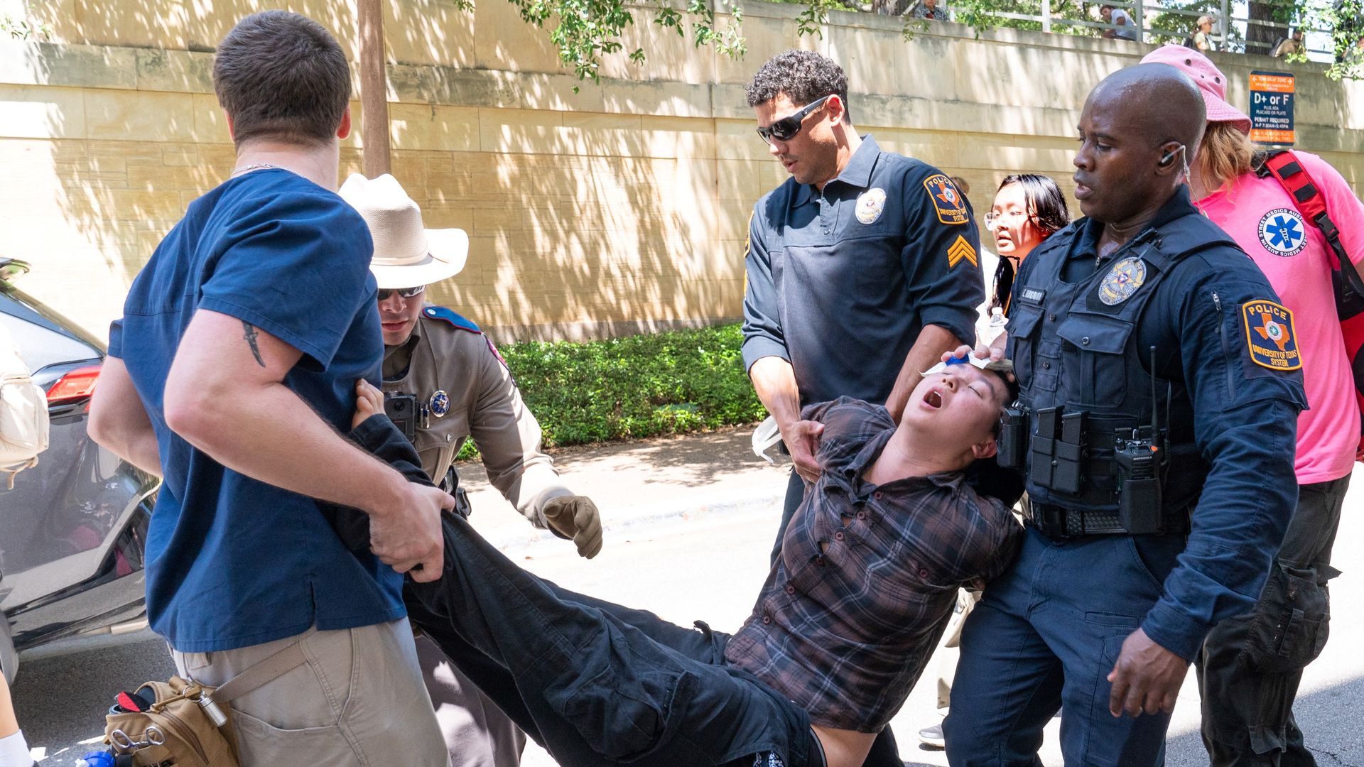 A person being arrested is taken away at UT campus 