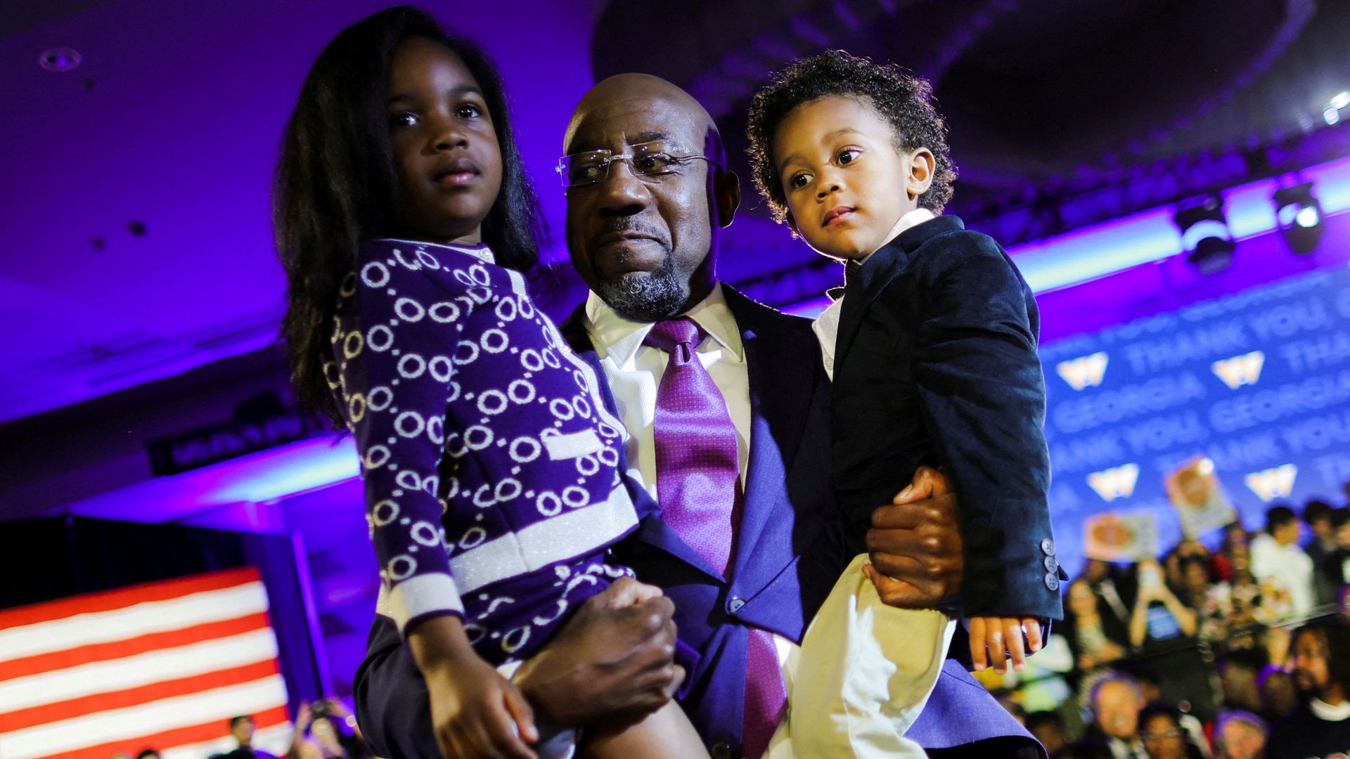 Sen. Raphael Warnock holds his daughter, Chloé, and his son, Caleb, at his election-night party in Atlanta.