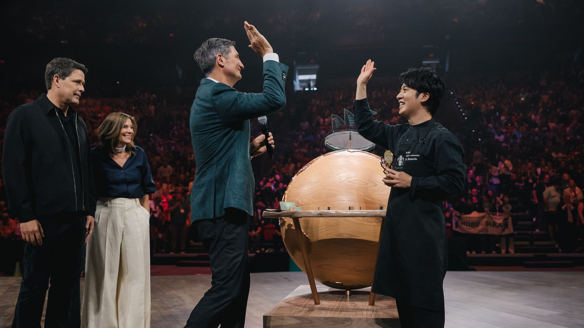 Starbucks had a barista competition. On the right of picture is the winner giving a high five to Starbucks CEO Brian Niccol.