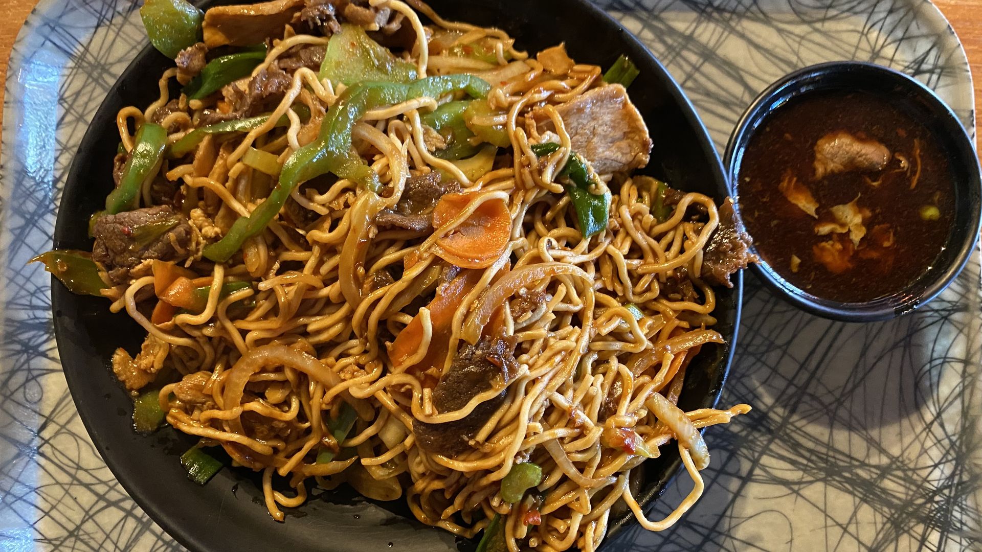 A bowl of stir fry noodles, meat and vegetables