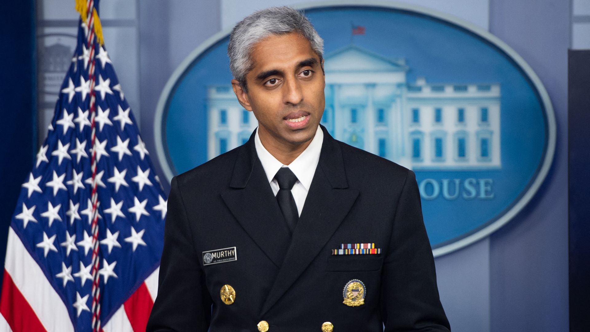 Photo of Vivek Murthy speaking from a podium at a White House briefing