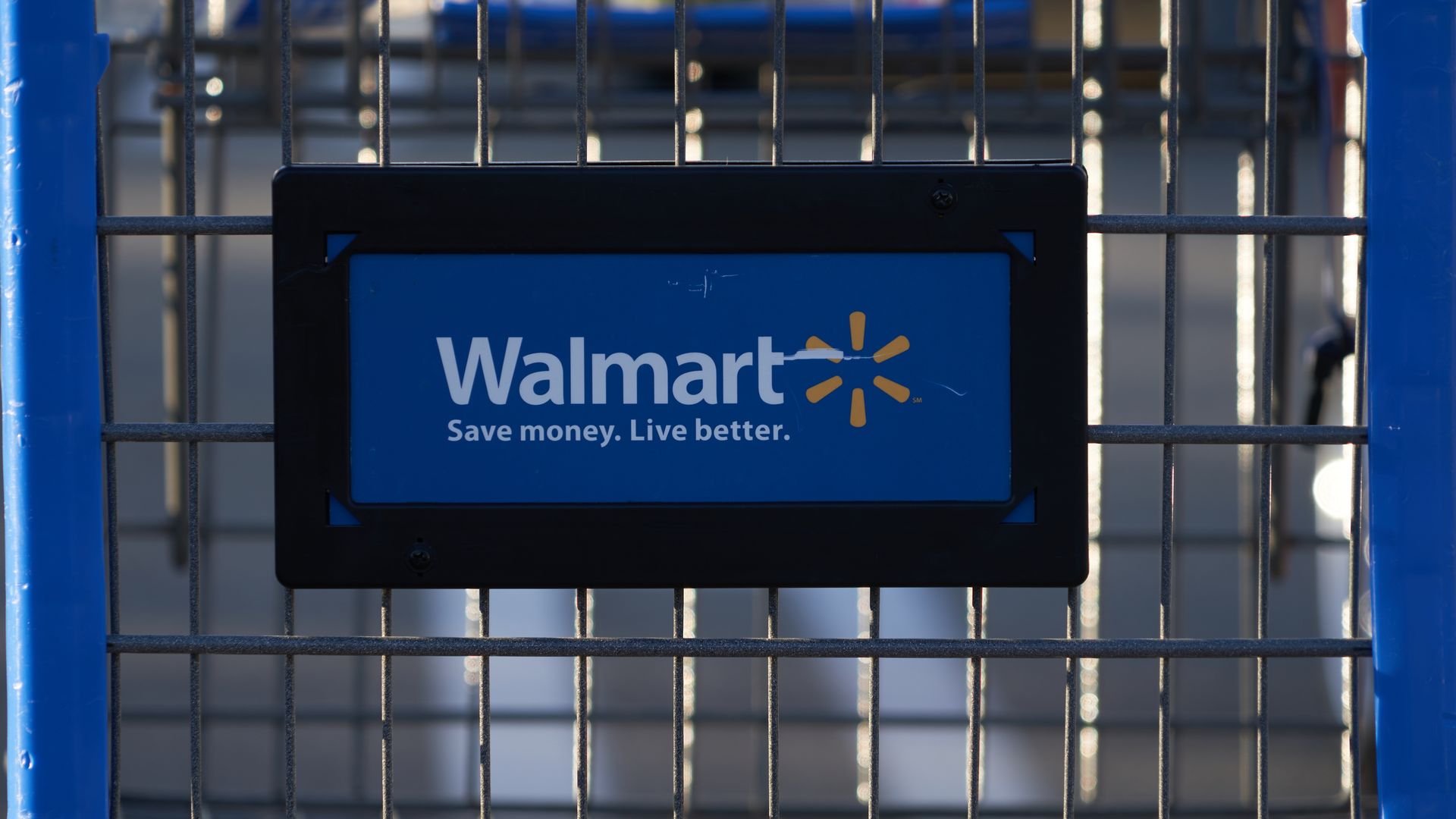 Photo of the front of a shopping cart with a Walmart sign.