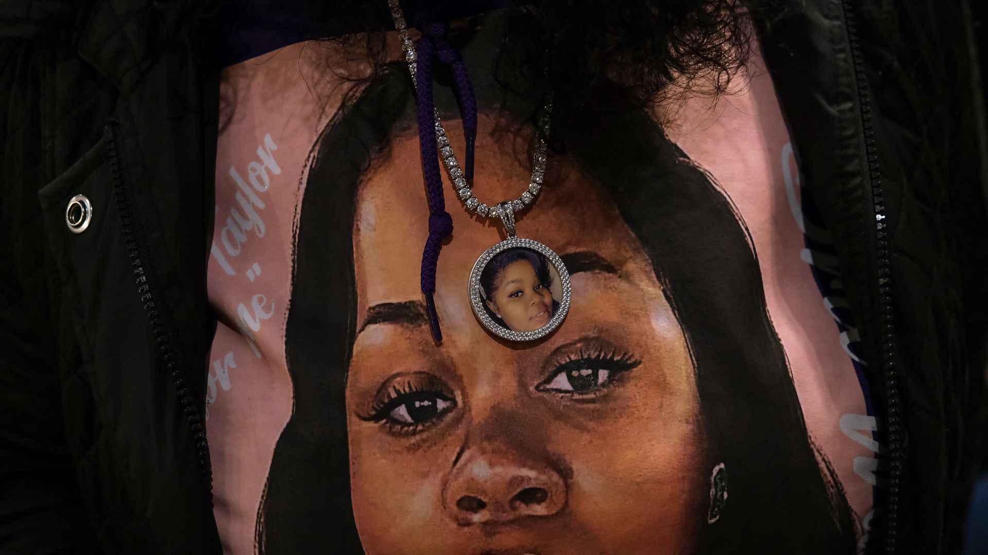 Bianca Austin wears a sweater and necklace with a photo of her niece Breonna Taylor at KULA Gallery during an unveiling of a Breonna Taylor painting on March12, 2022 in Louisville, Kentucky.